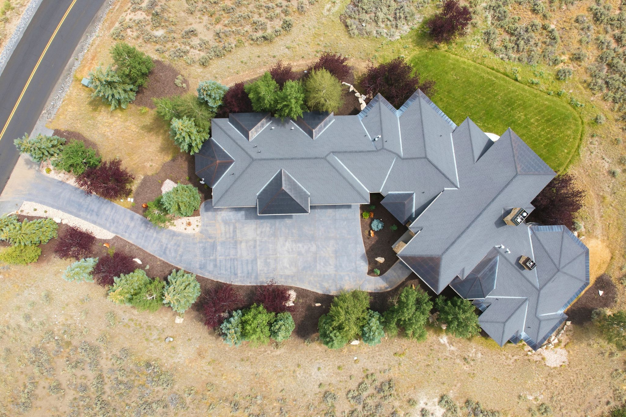 Spacious property featuring a large, multi-gabled roofline and extensive paved driveway