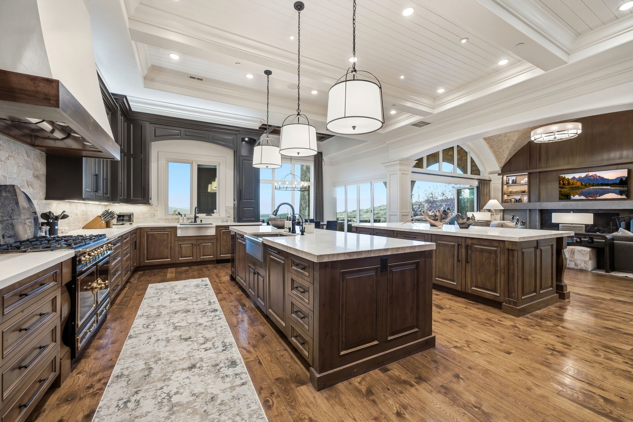 Gourmet kitchen featuring a built-in range with a custom wood hood, stone backsplash, and an integrated farmhouse sink