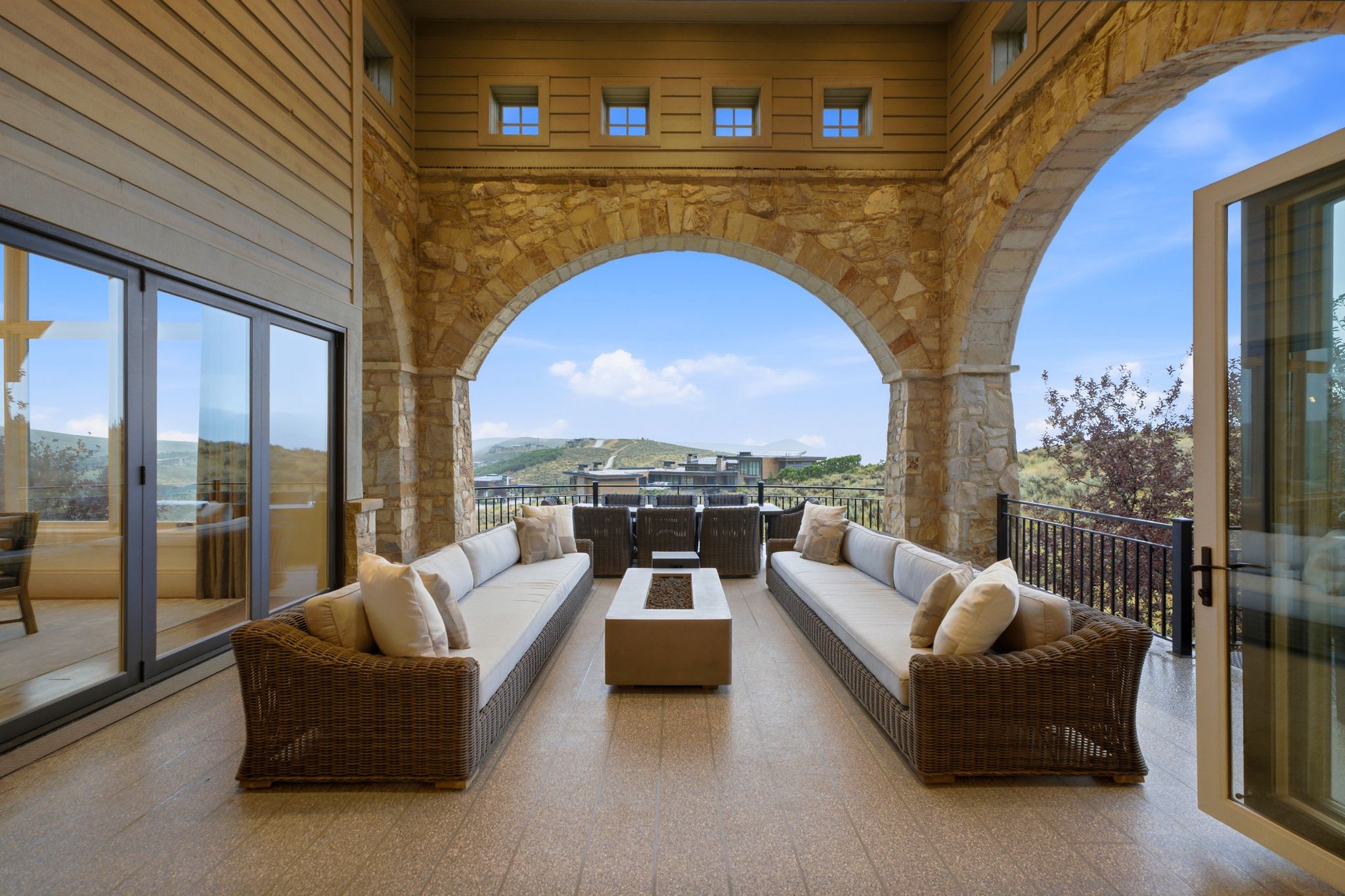Expansive covered patio featuring stone archways and a built-in fire pit