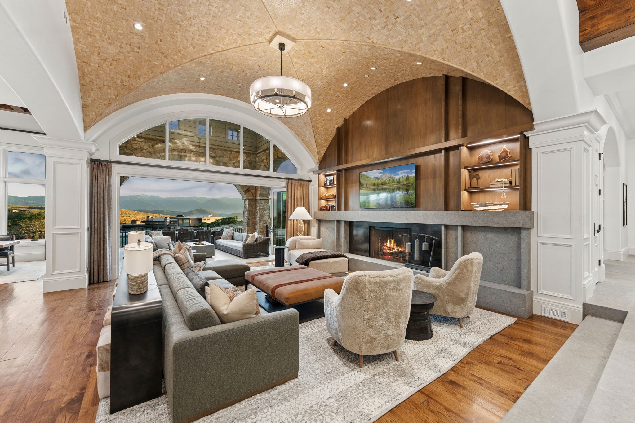 Vaulted wood-finish ceiling featuring recessed lighting and a central chandelier