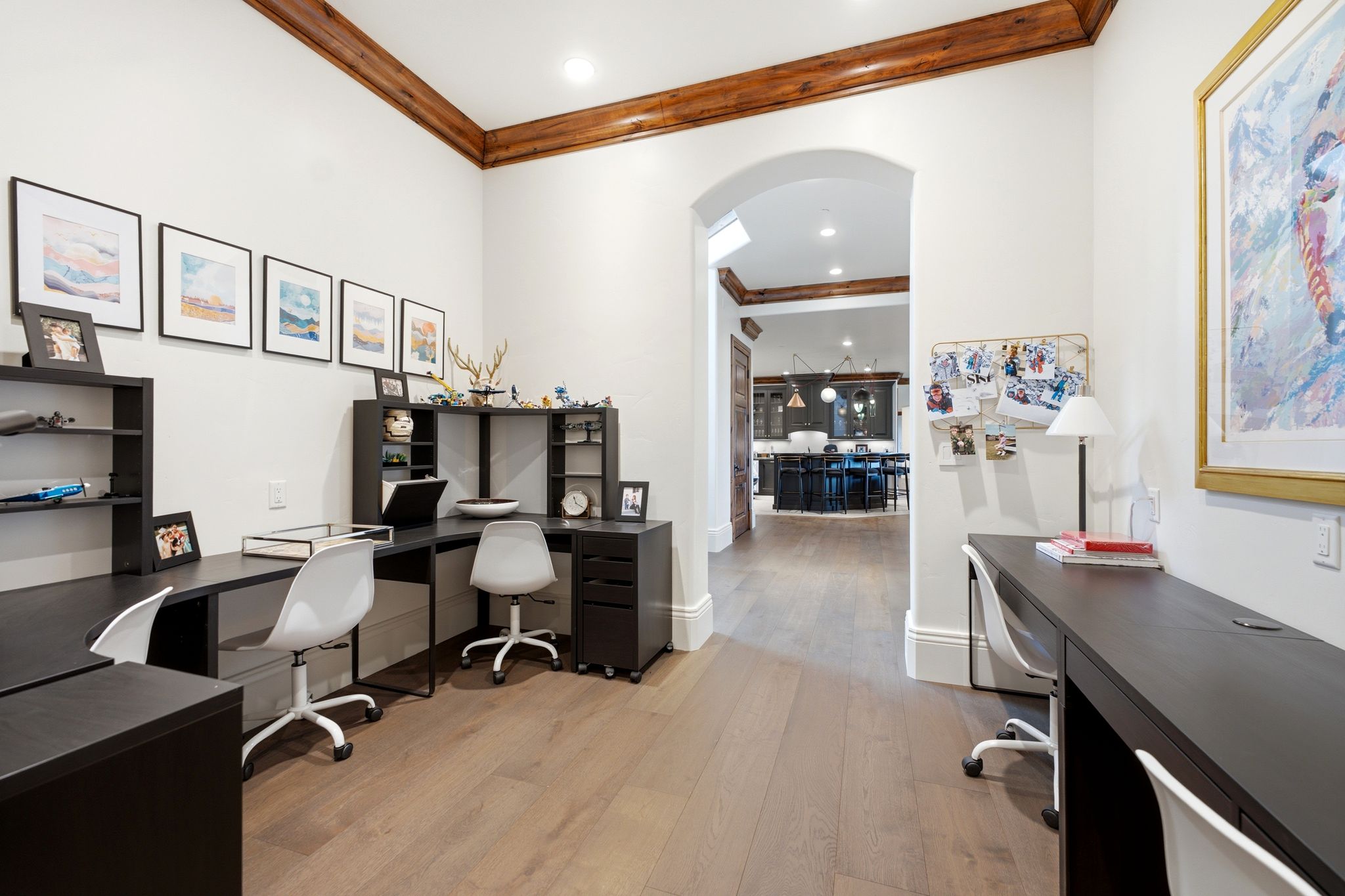 Dedicated office space featuring wood-finish flooring, white walls, and a coffered ceiling with exposed wood beams
