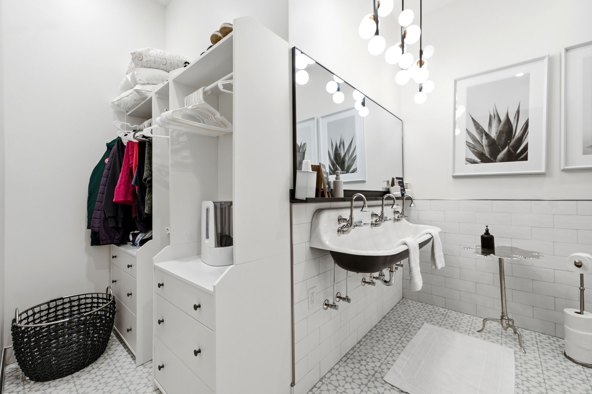 Contemporary bathroom featuring a black double basin sink, chrome fixtures, and a large wall mirror