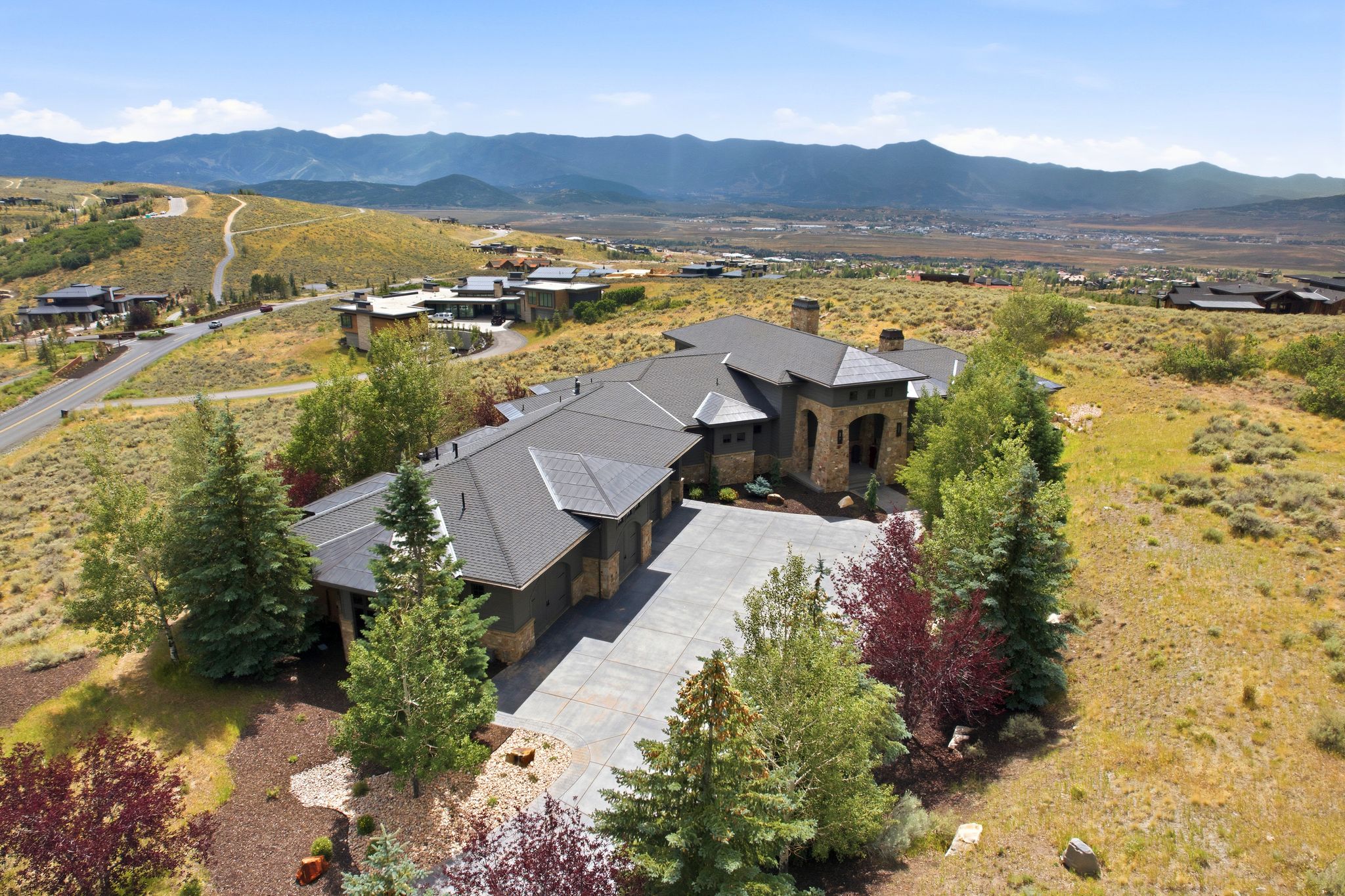 Expansive residence featuring a multi-gabled roofline and a stone facade