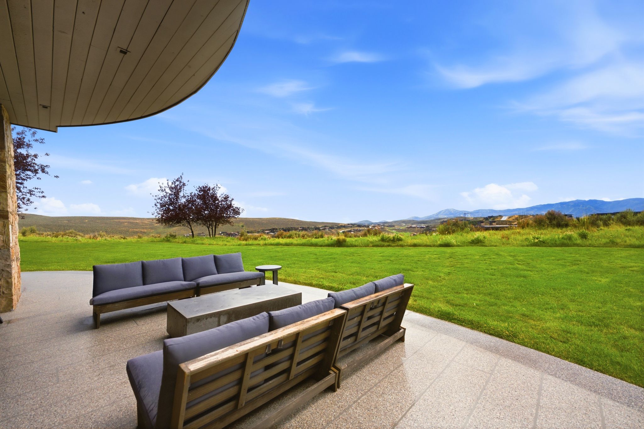 Expansive patio featuring light-toned tile flooring and a curved overhang