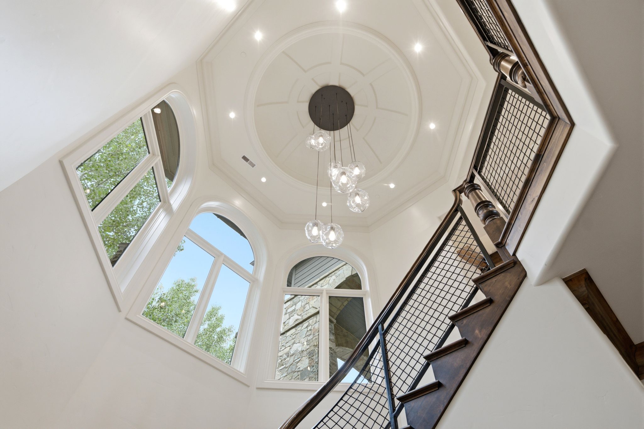 Architectural ceiling detail with recessed lighting and a multi-light pendant fixture