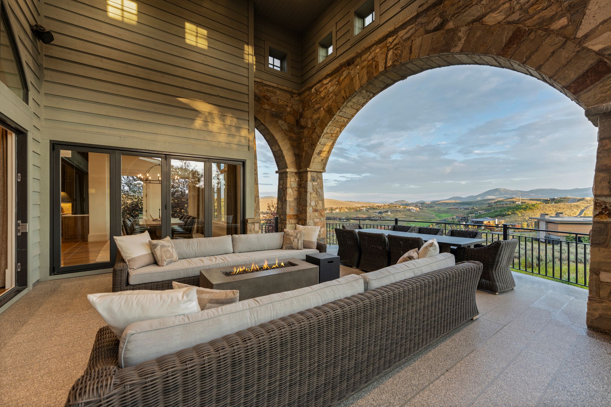 Expansive outdoor patio featuring stone archways and a fire pit