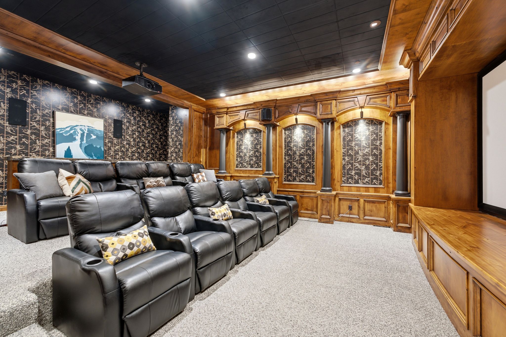 Dedicated media room featuring tiered seating and a large projection screen