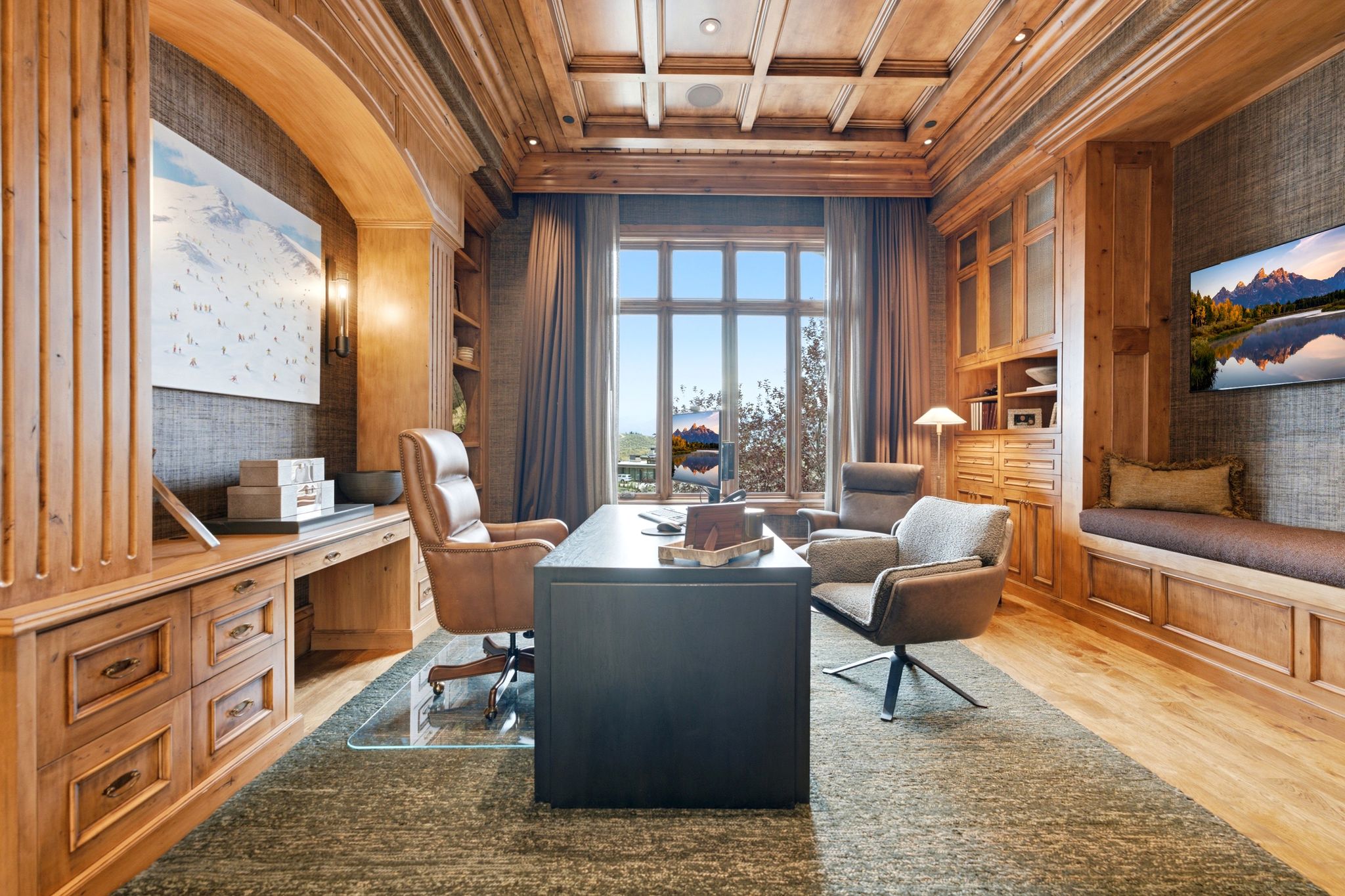 Custom office featuring extensive wood-finish cabinetry, built-in shelving, and a coffered wood-finish ceiling