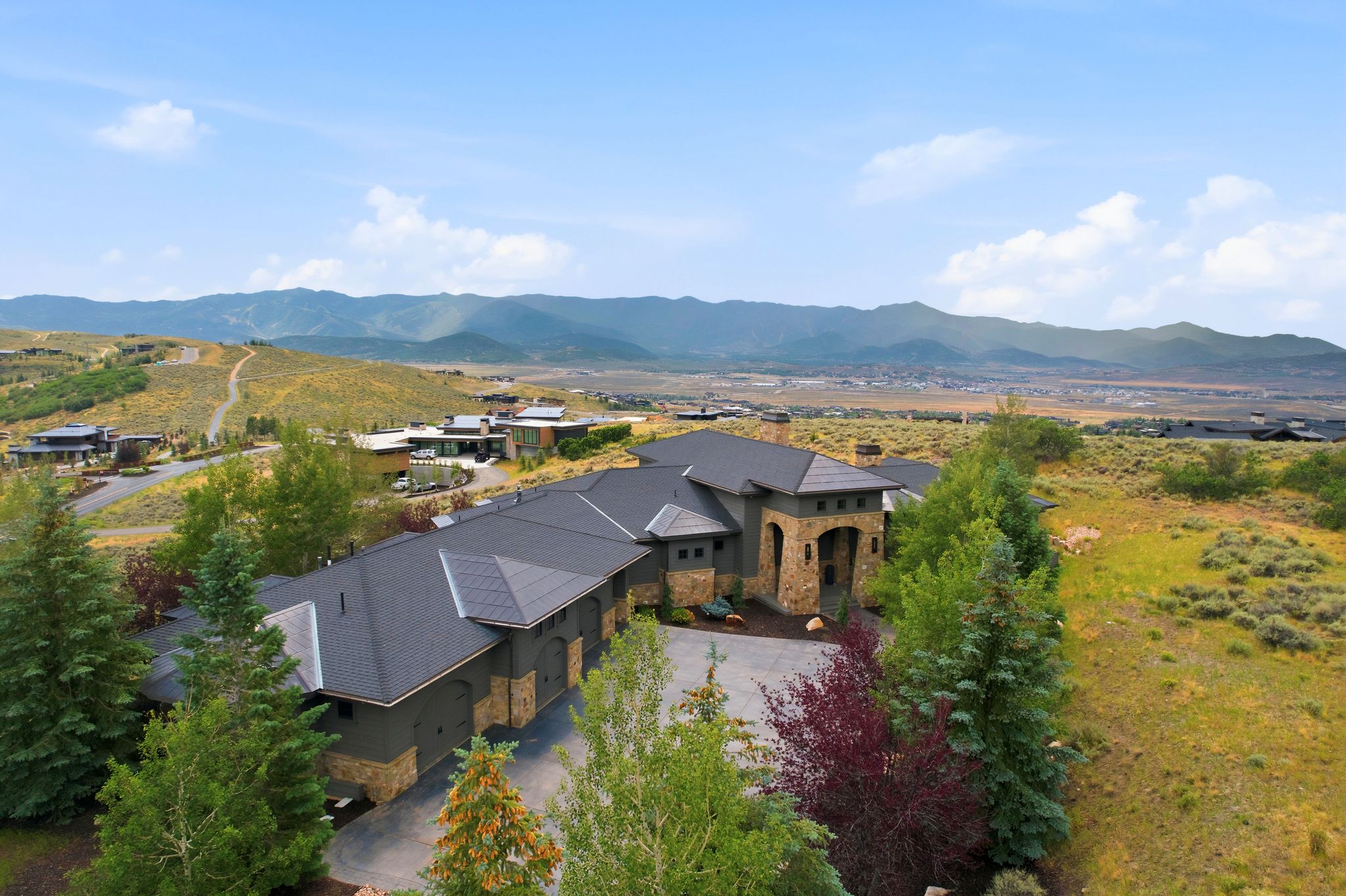 Expansive property featuring a multi-car garage, stone and stucco exterior, and a prominent arched entryway