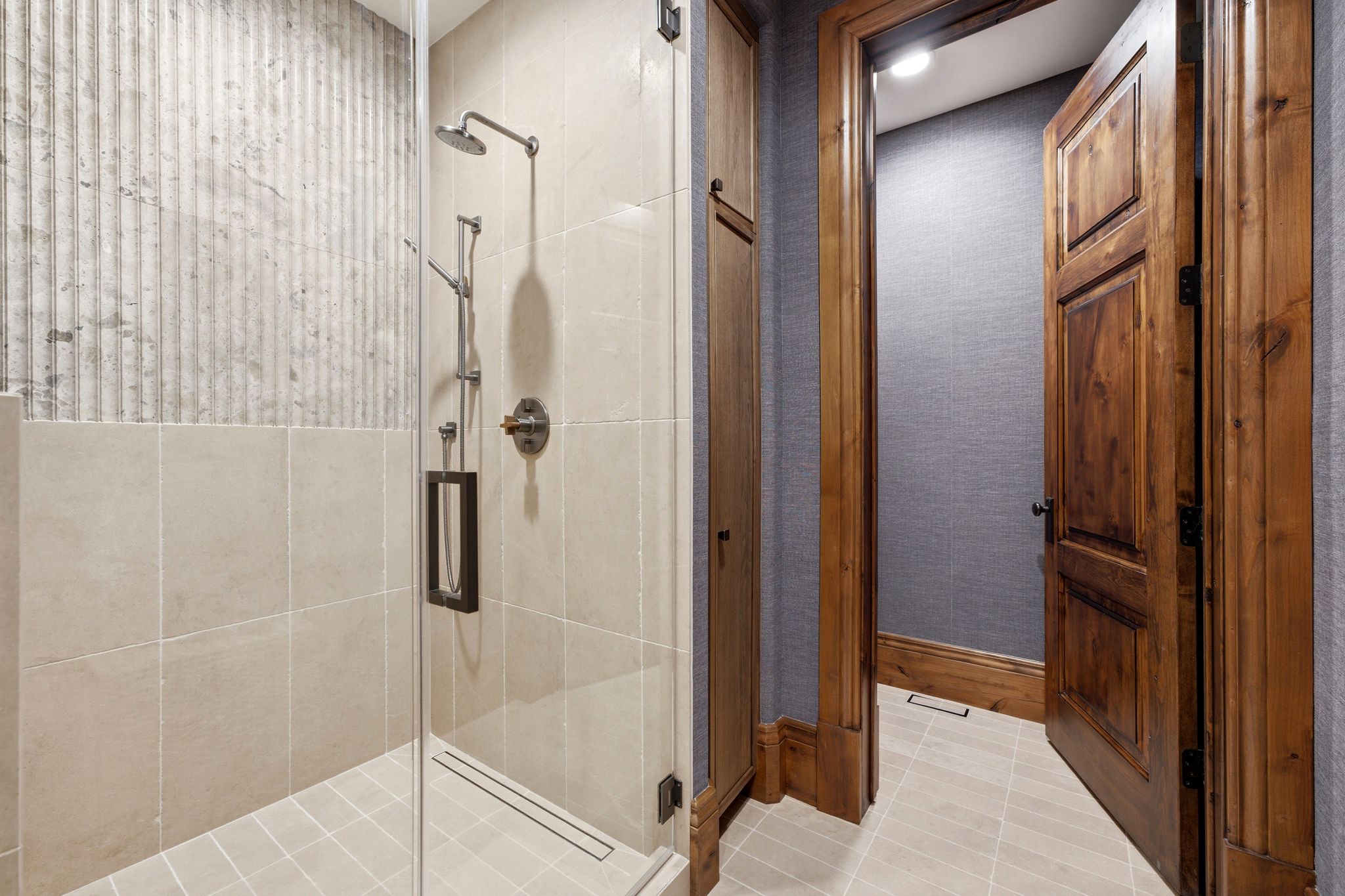Walk-in shower featuring a glass enclosure and a rainfall showerhead