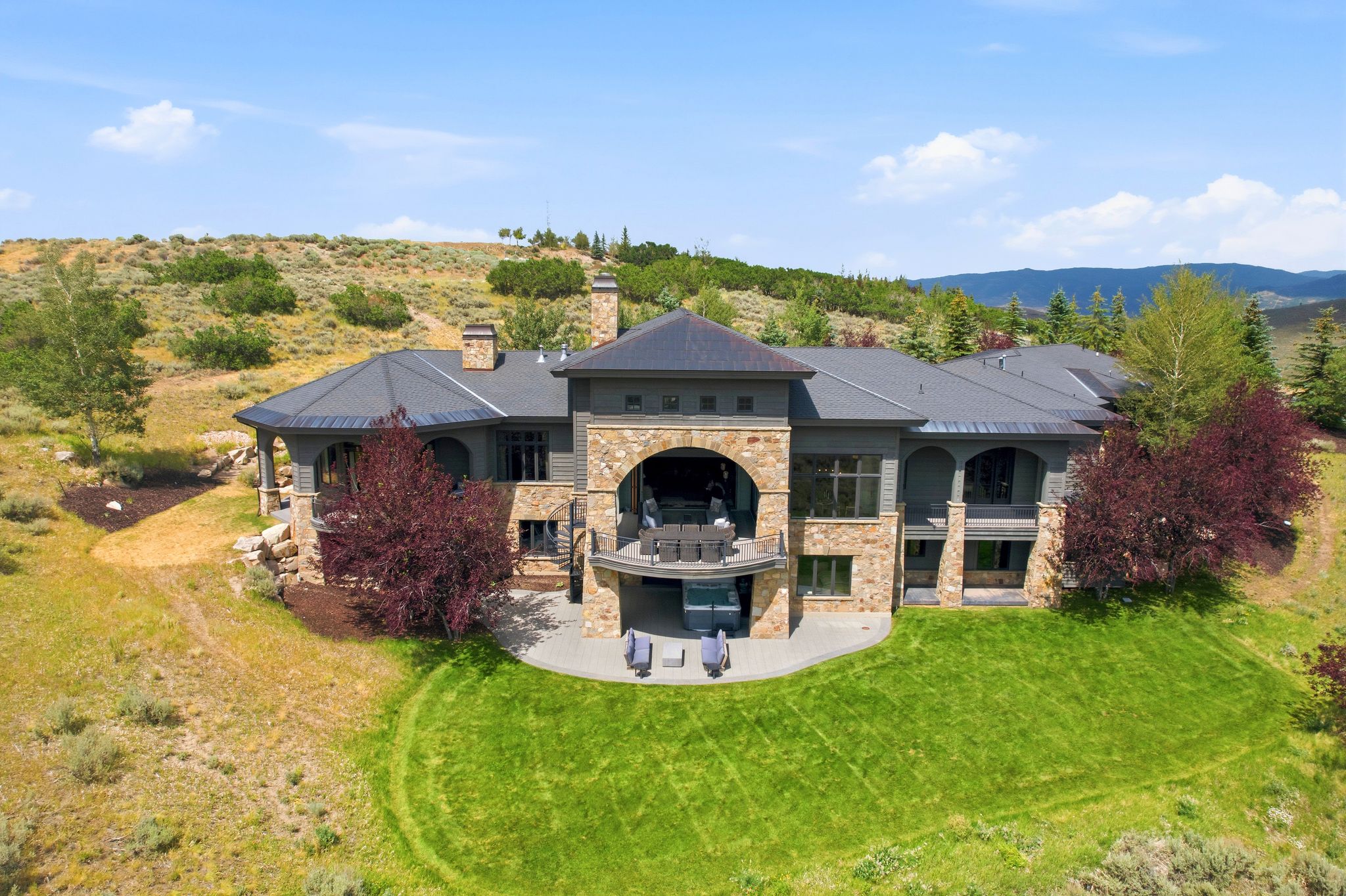 Multi-level residence featuring extensive stone veneer and dark siding