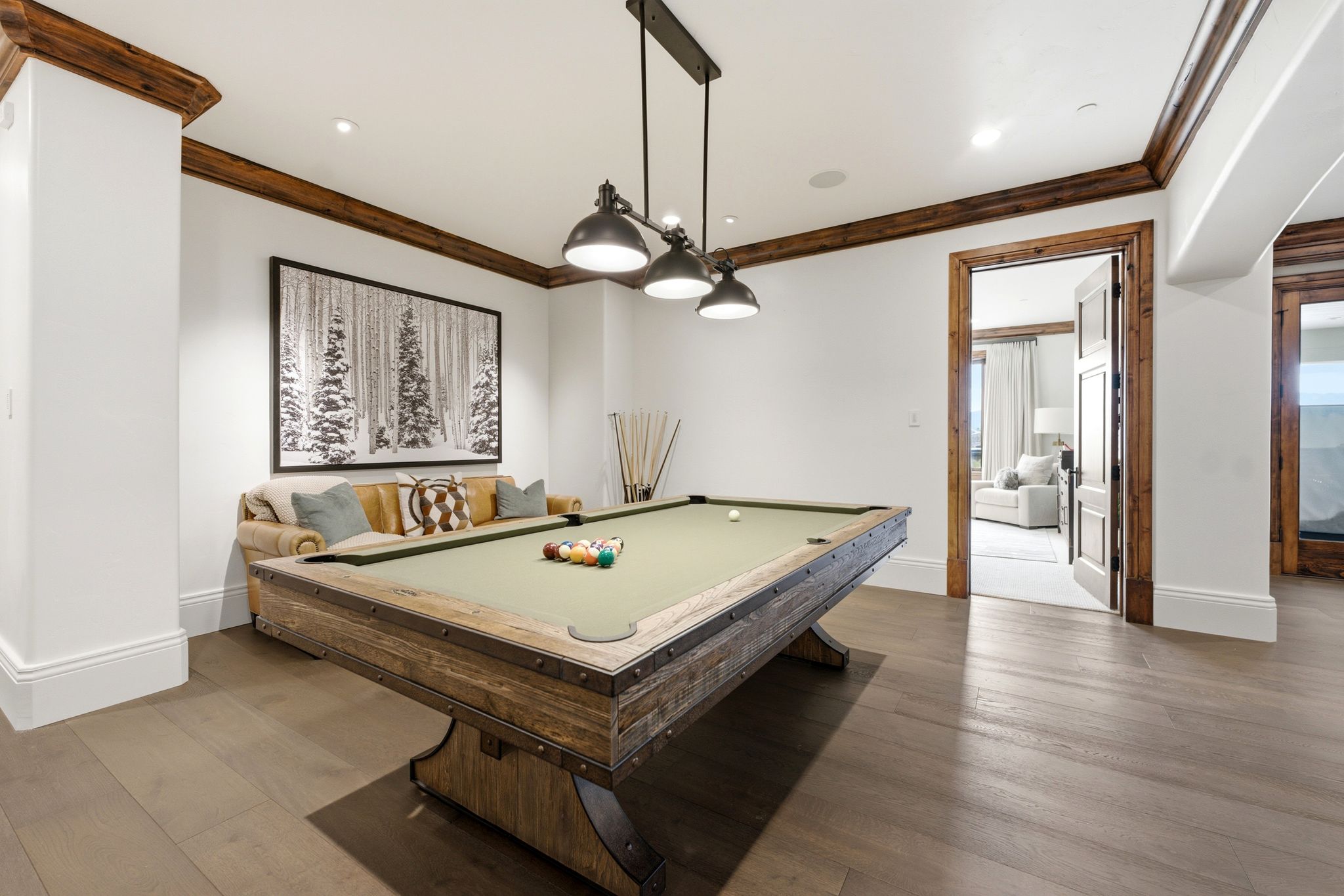 Recreational room featuring wood-finish flooring, white walls, and a recessed ceiling with wood trim accents