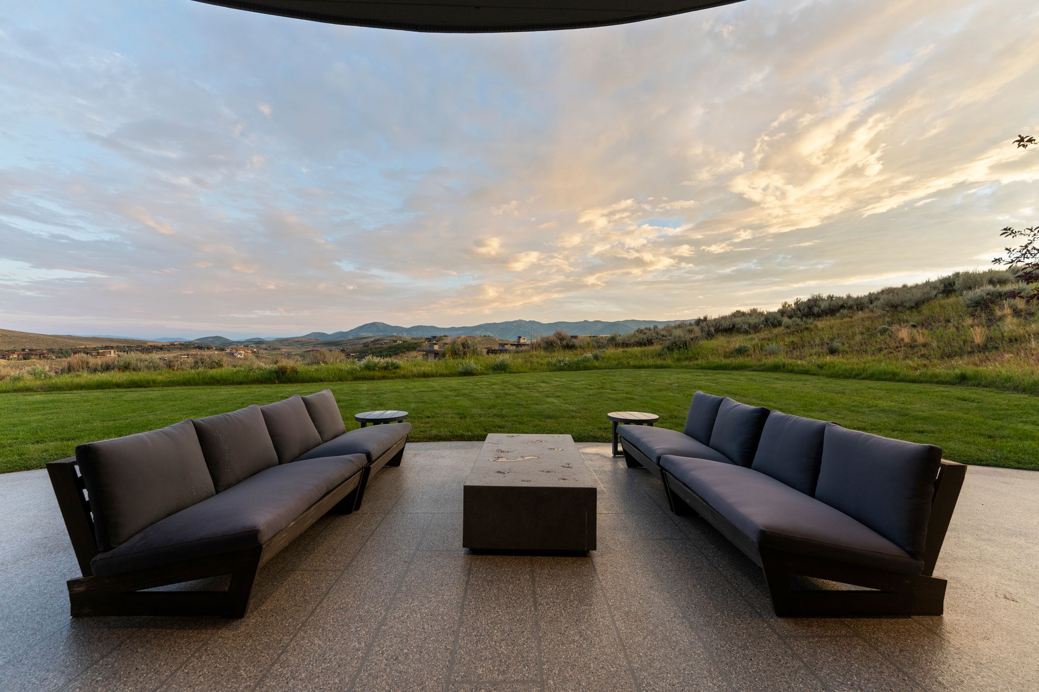 Expansive patio featuring large format tile flooring and a built-in fire pit