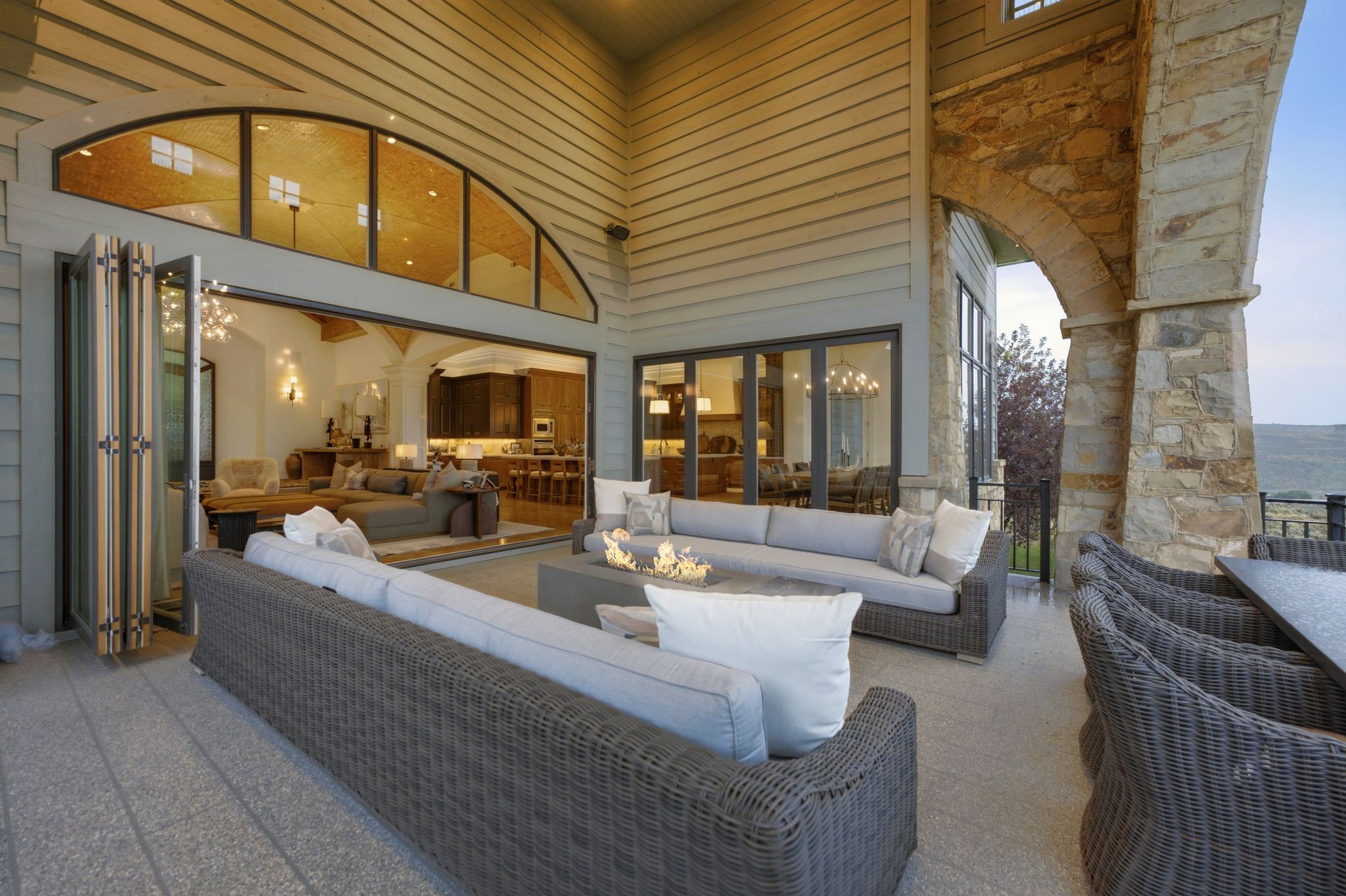 Expansive outdoor patio featuring stone column arches and a stone-clad exterior