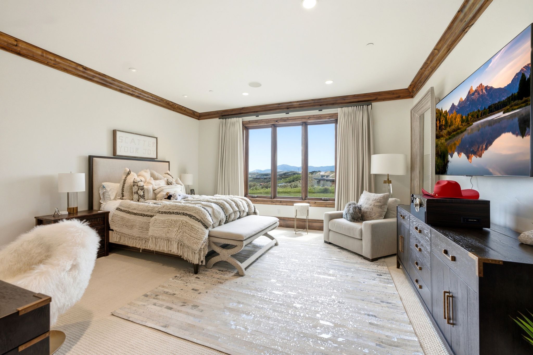 Spacious bedroom featuring expansive windows, wood-finish trim, recessed lighting, and soft white walls