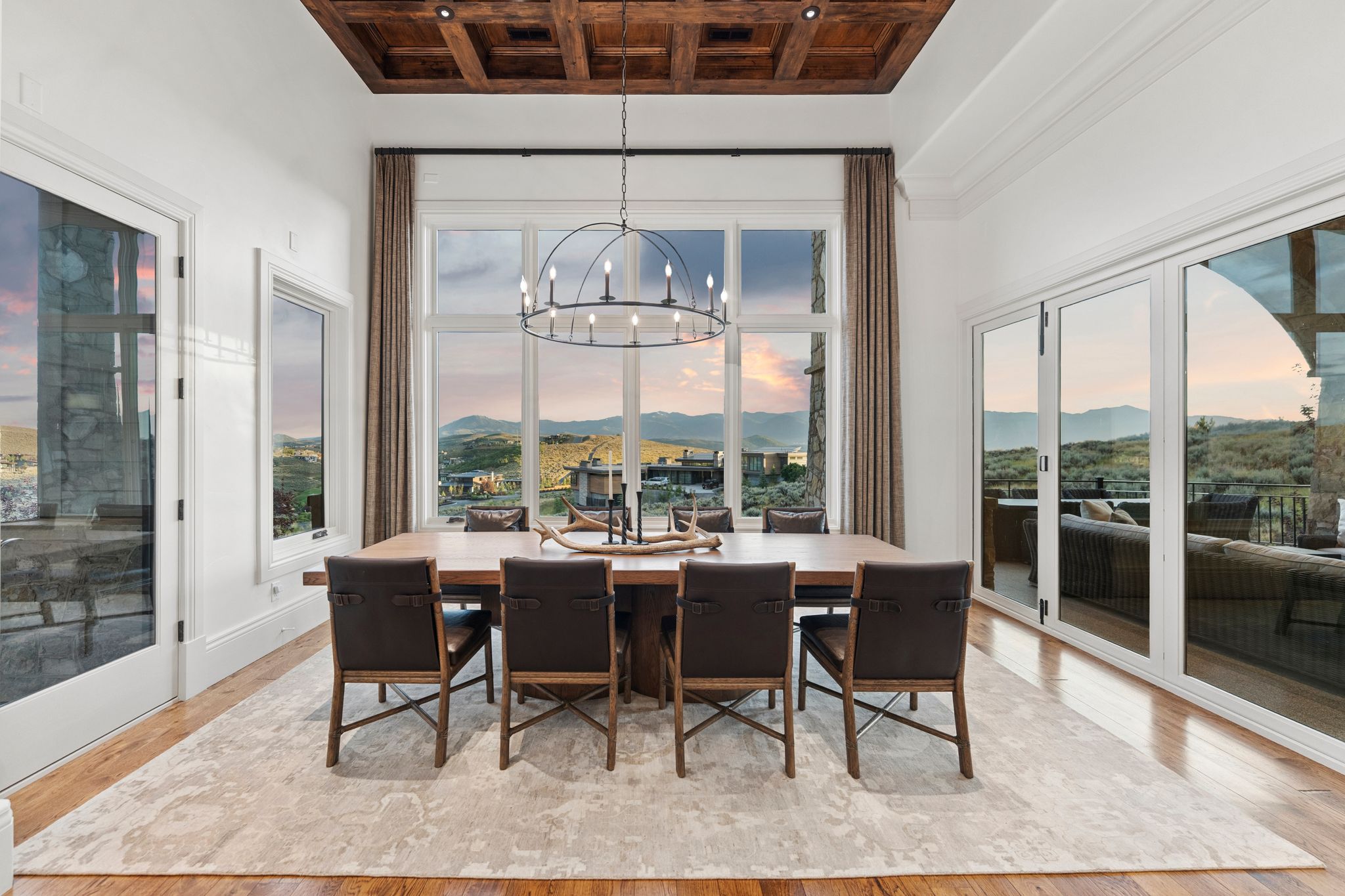 Dining area featuring a coffered wood ceiling, central chandelier, and wood-finish flooring