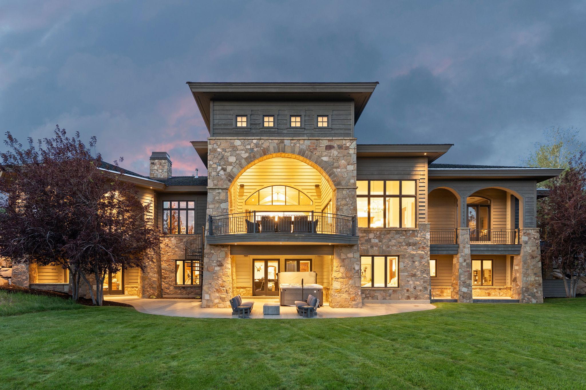Expansive stone and siding exterior with multiple levels of balconies and patios