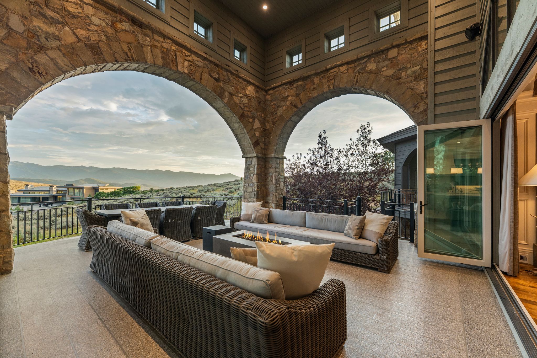 Expansive stone archways define this covered outdoor living space with a large format tile floor