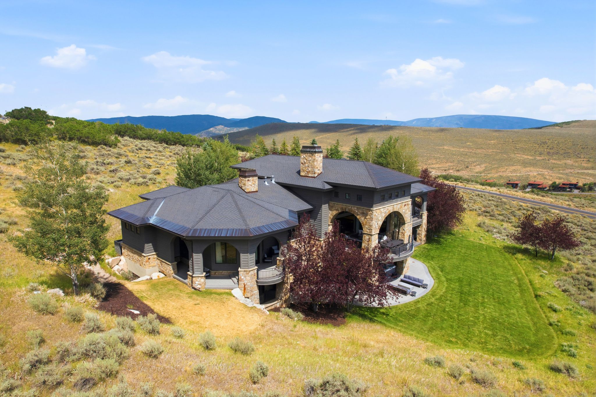 Stone and stucco exterior with dark-toned roofing and multiple chimneys