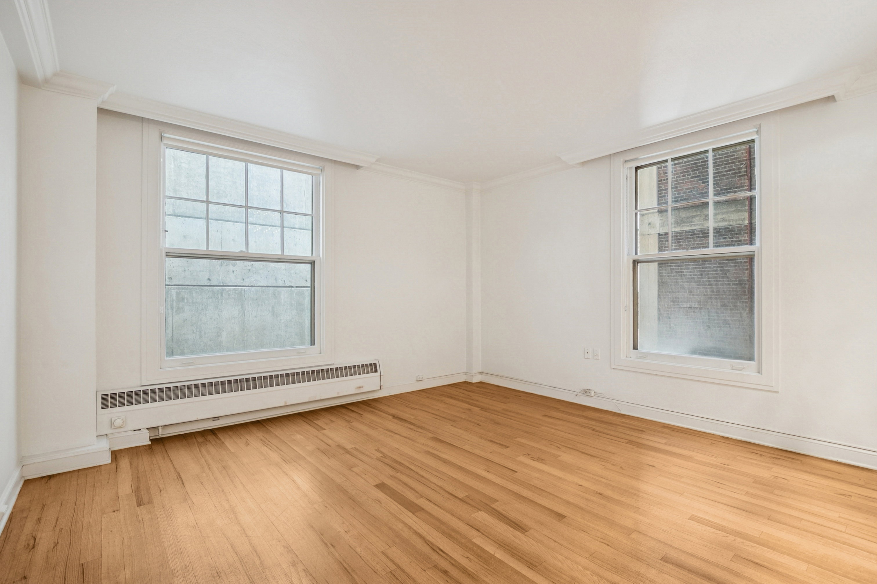 White-painted room featuring hardwood flooring, and crown molding