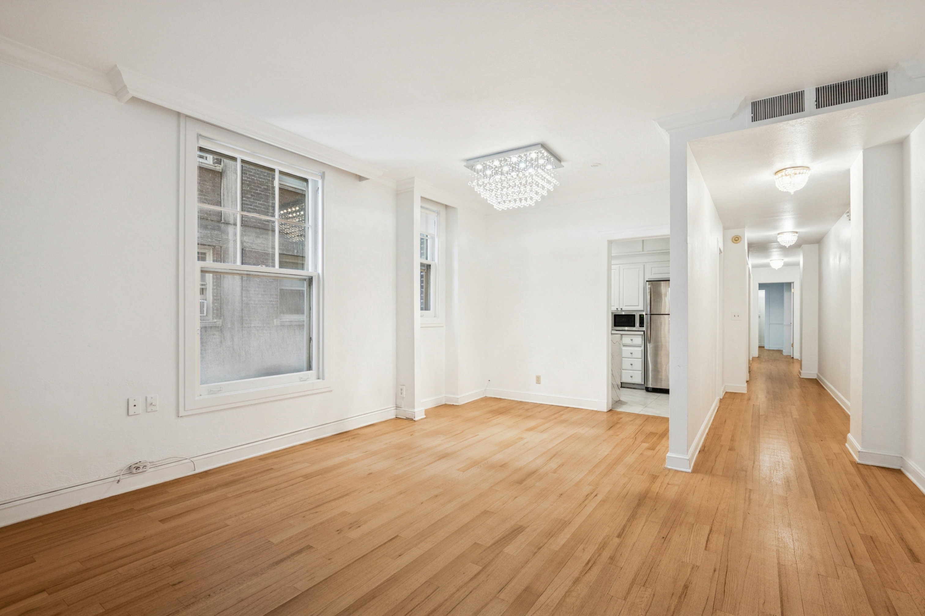 Spacious interior featuring hardwood flooring and white walls