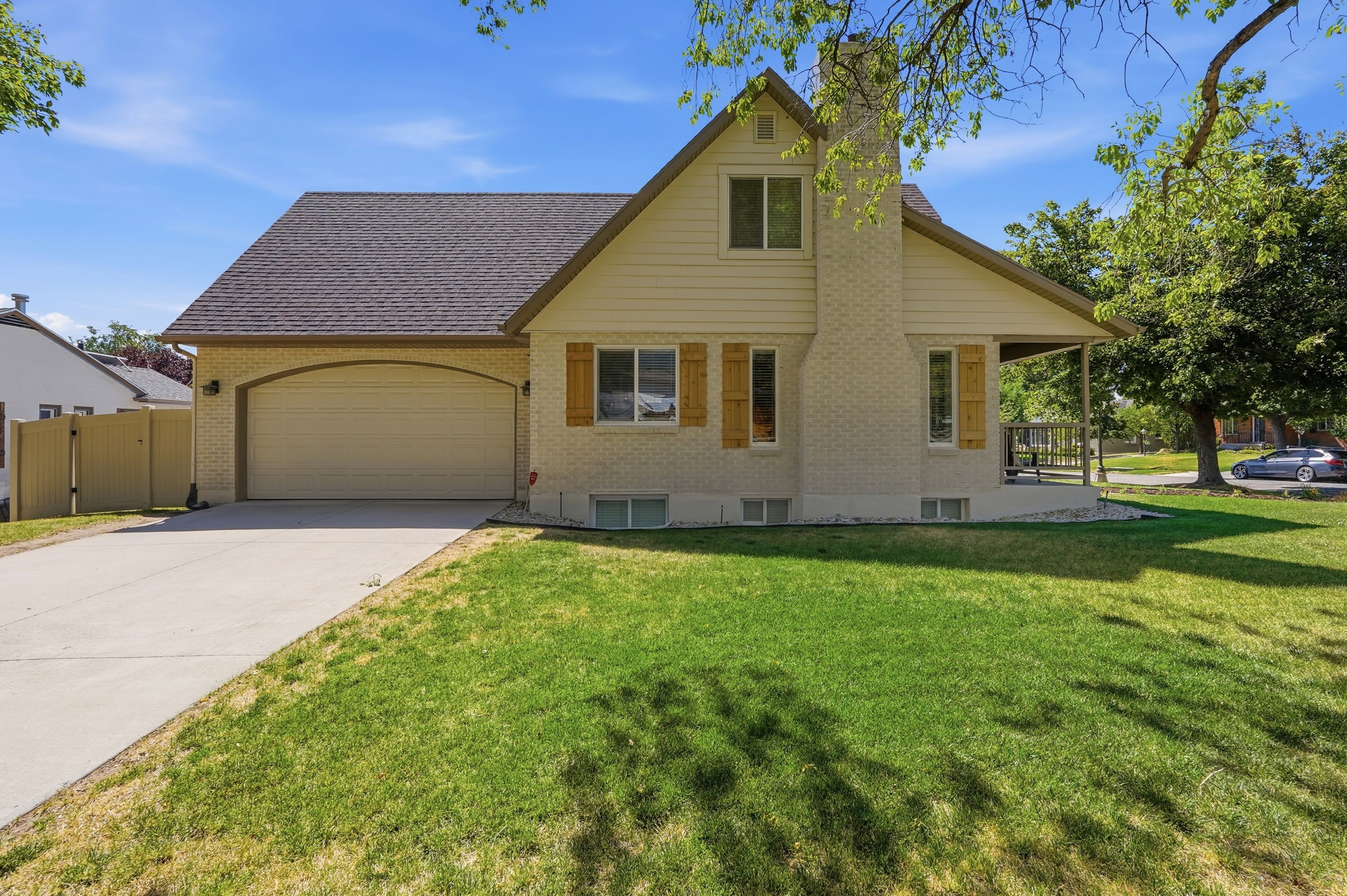 Traditional-style home featuring a light-colored brick exterior and an attached two-car garage with an arched entry