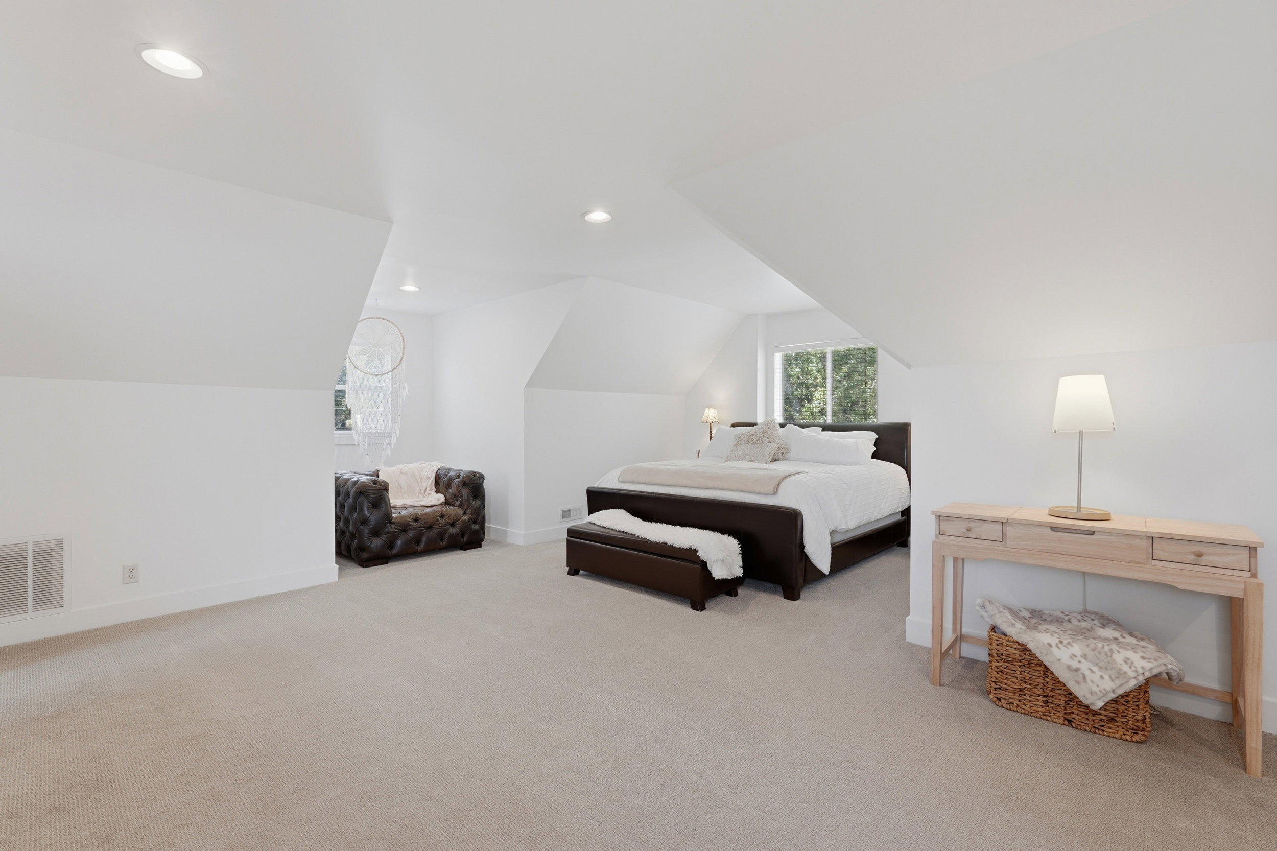 Large owners suite upstairs. Spacious room featuring vaulted ceilings, recessed lighting, and light-colored carpeting