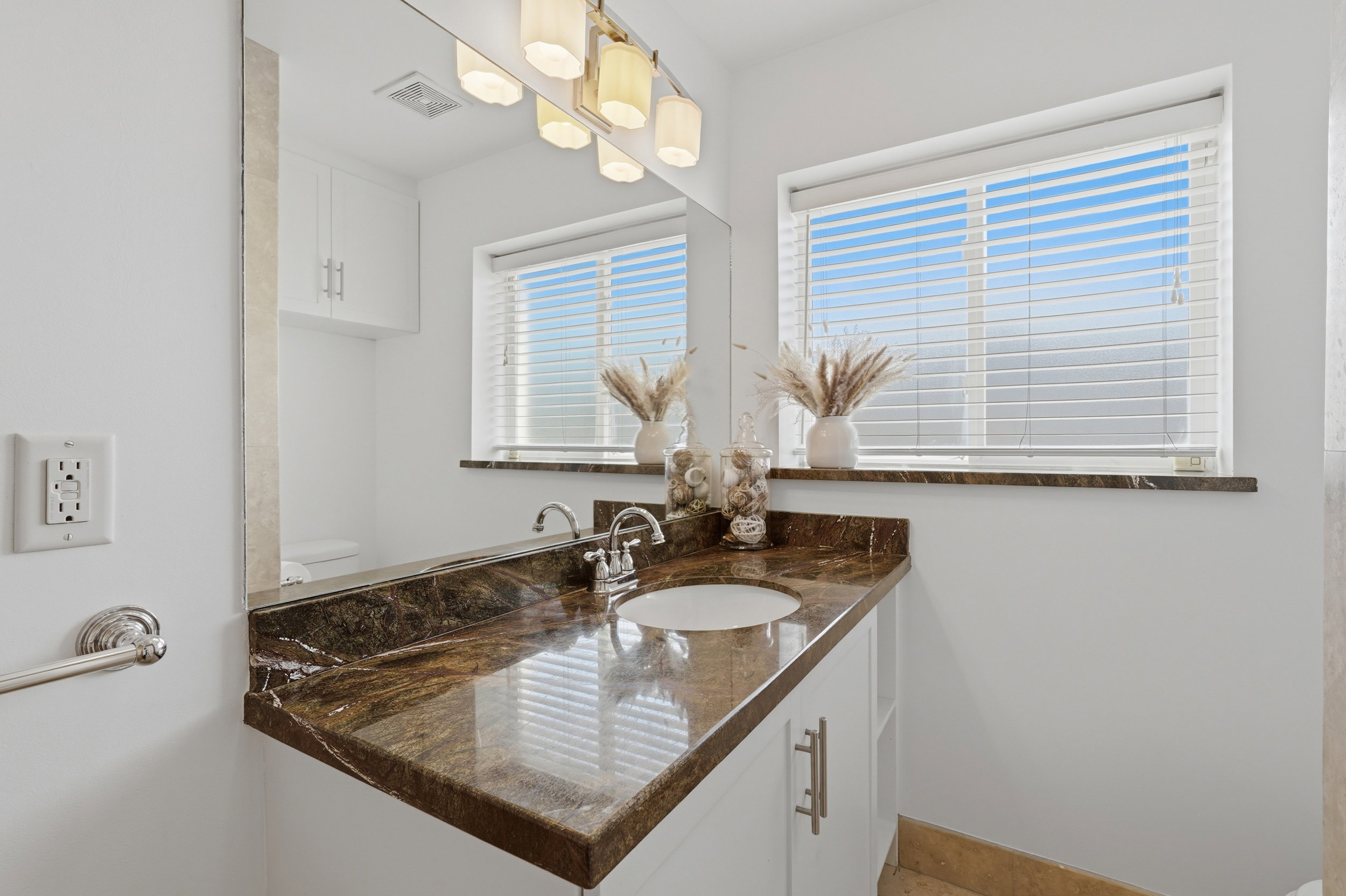 Vanity with a polished stone countertop and integrated sink