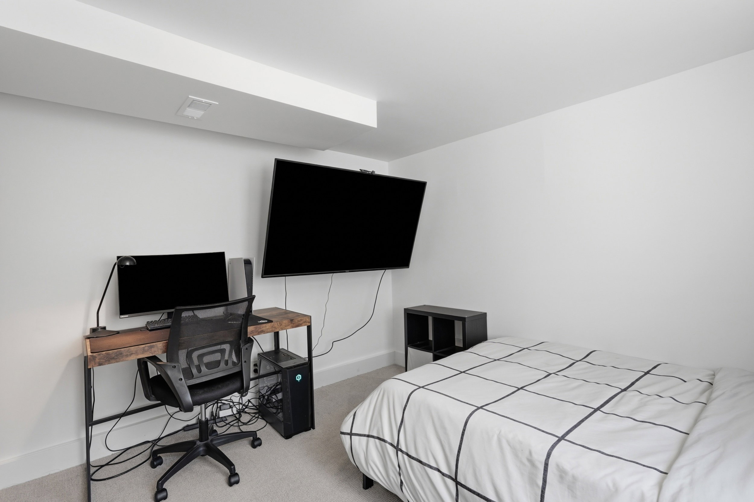 Neutral white wall finishes, built-in ceiling beam, recessed lighting, and light-toned carpeting