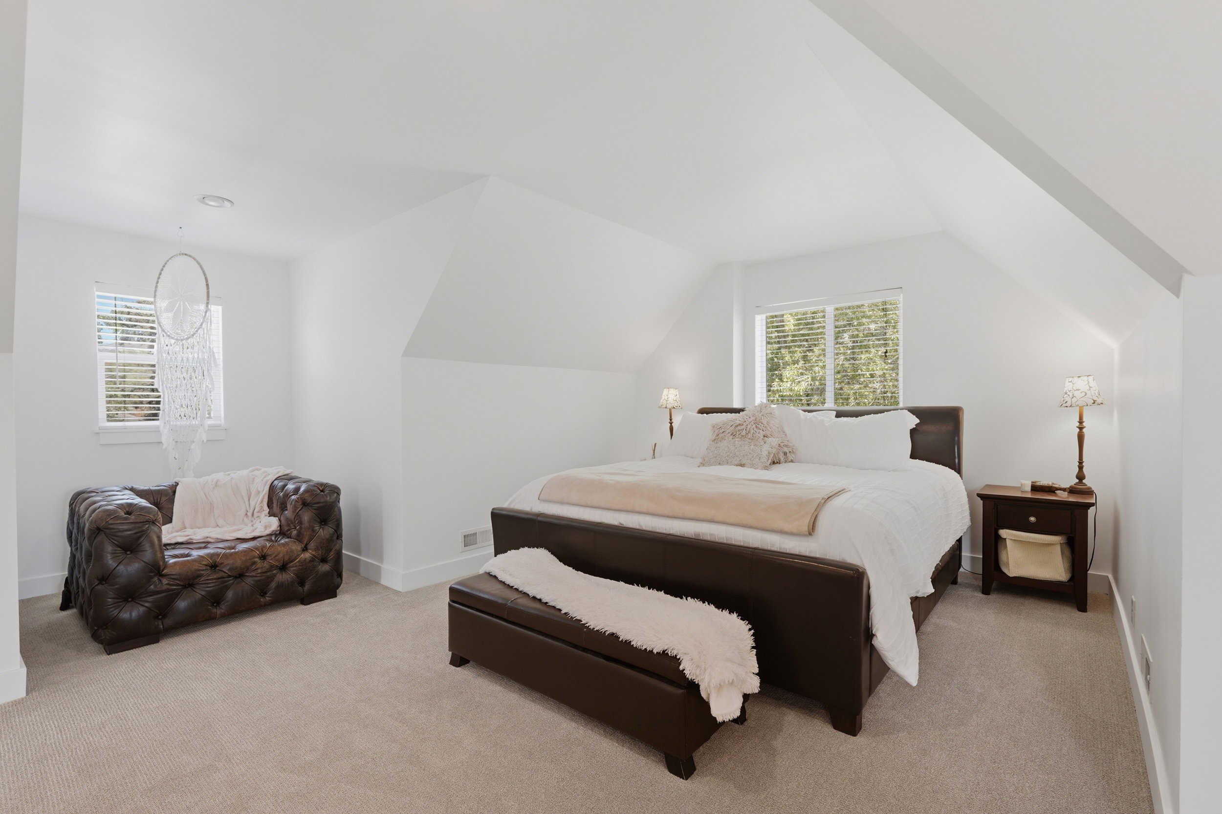Large owners suite upstairs. Carpeted room featuring crisp white walls and a vaulted ceiling