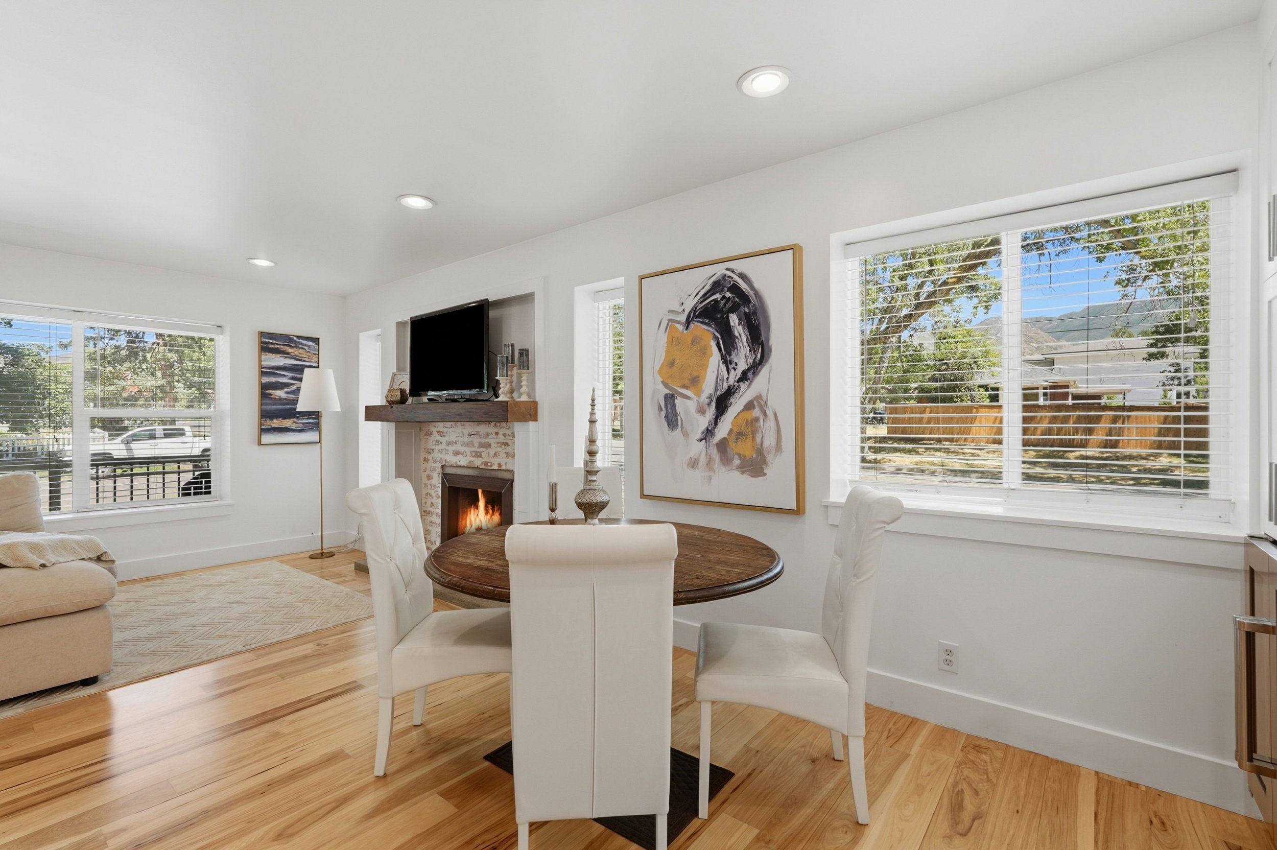 Living area featuring wood-finish flooring, a brick fireplace with a wood mantle, and recessed lighting