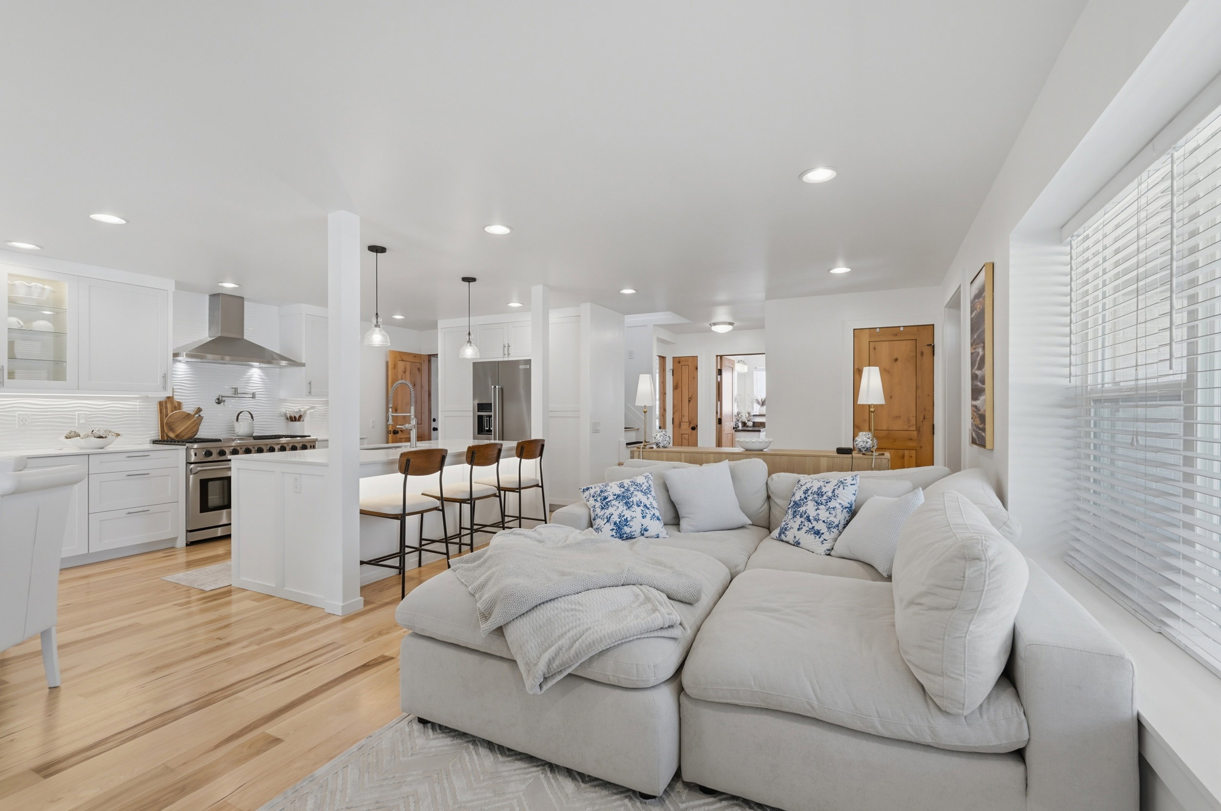 Bright living area featuring wood-finish flooring, recessed lighting, and white window blinds