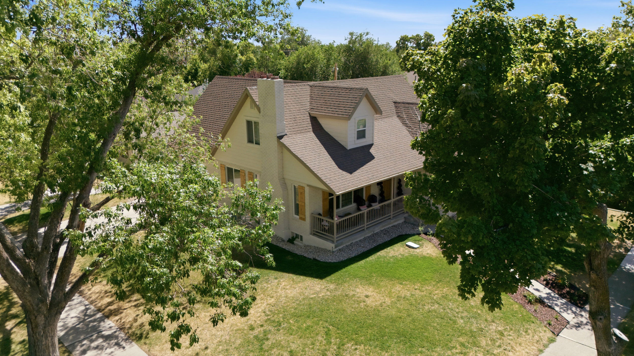 Traditional-style residence with light-colored siding and a brown shingle roof
