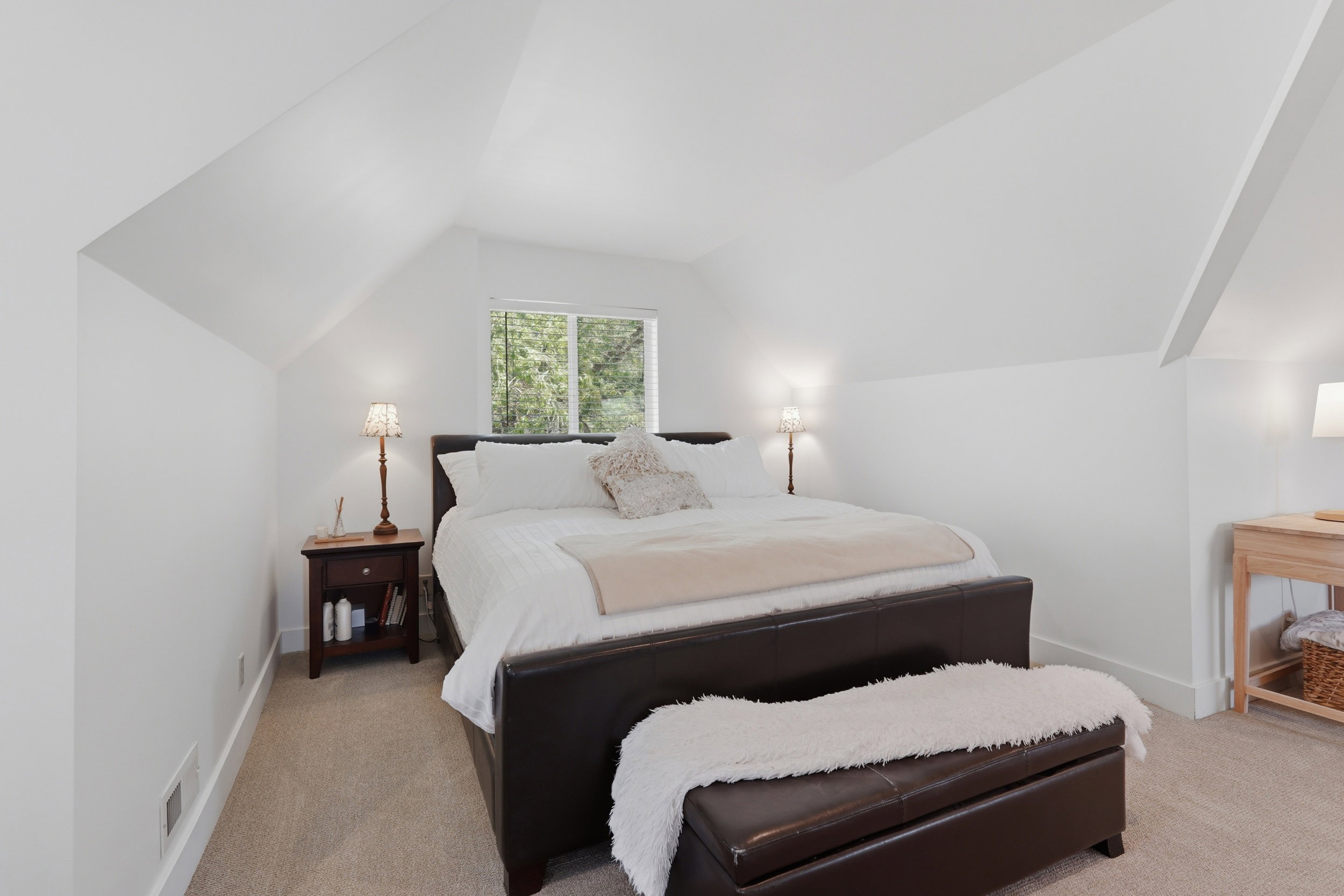 Large owners suite upstairs. Carpeted room with a vaulted ceiling and a rectangular window