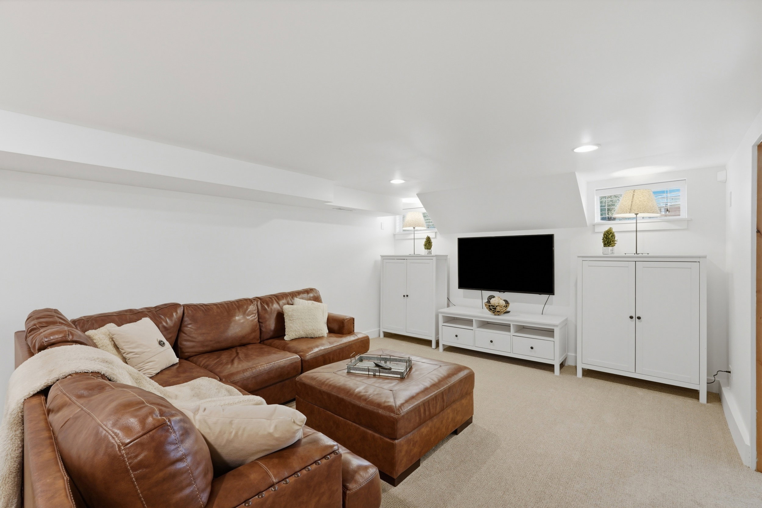 Carpeted recreation room featuring white walls, recessed lighting, and sloped ceilings