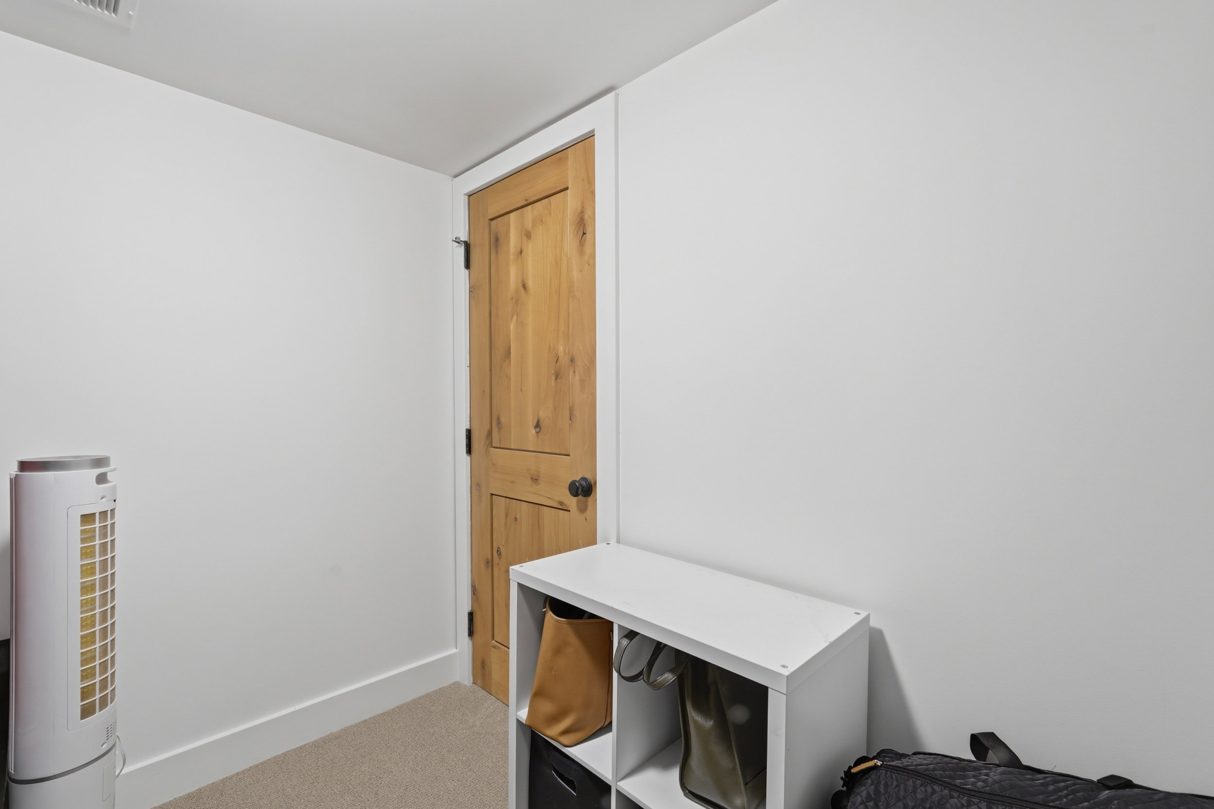 Storage room. Natural wood-finish interior door with dark hardware