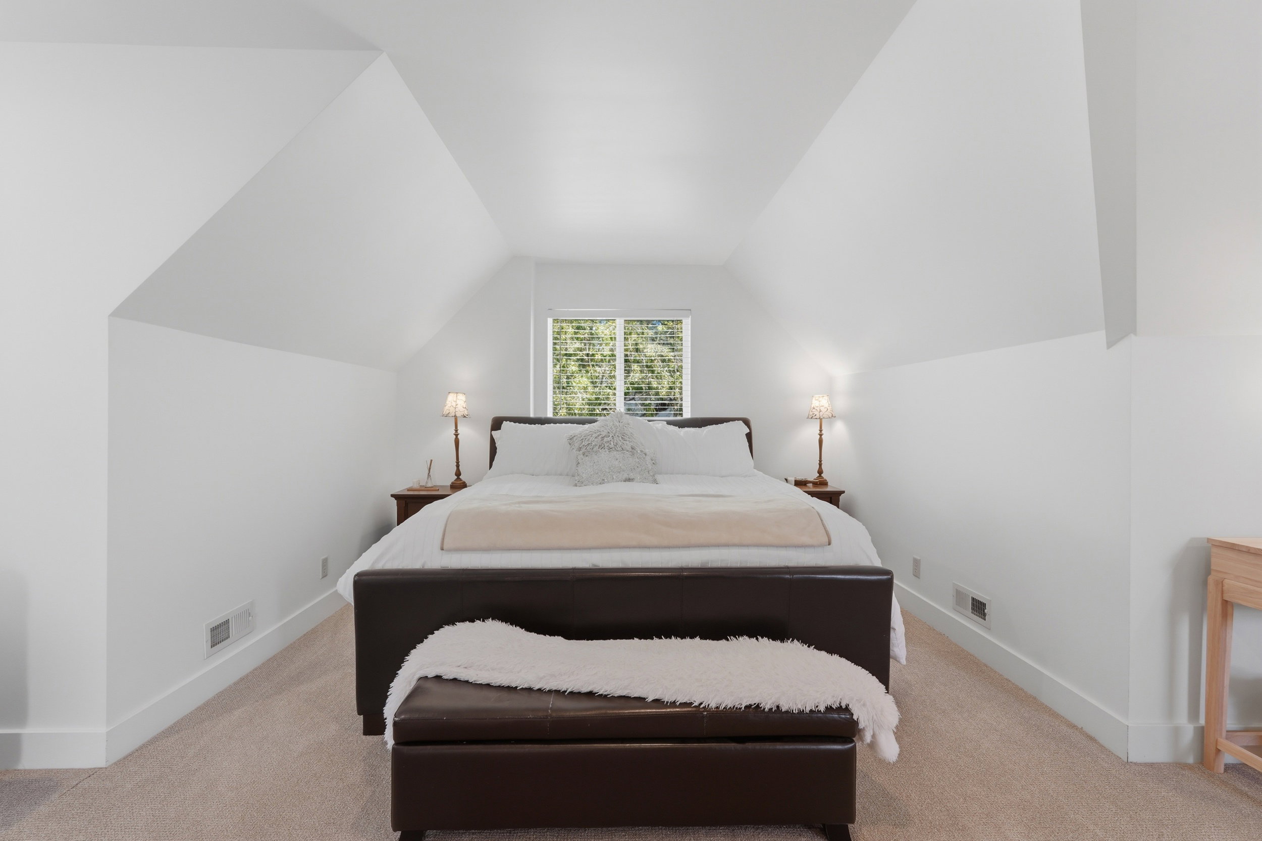 Large owners suite upstairs. Carpeted room featuring sloped ceilings, white walls, and a window with natural light