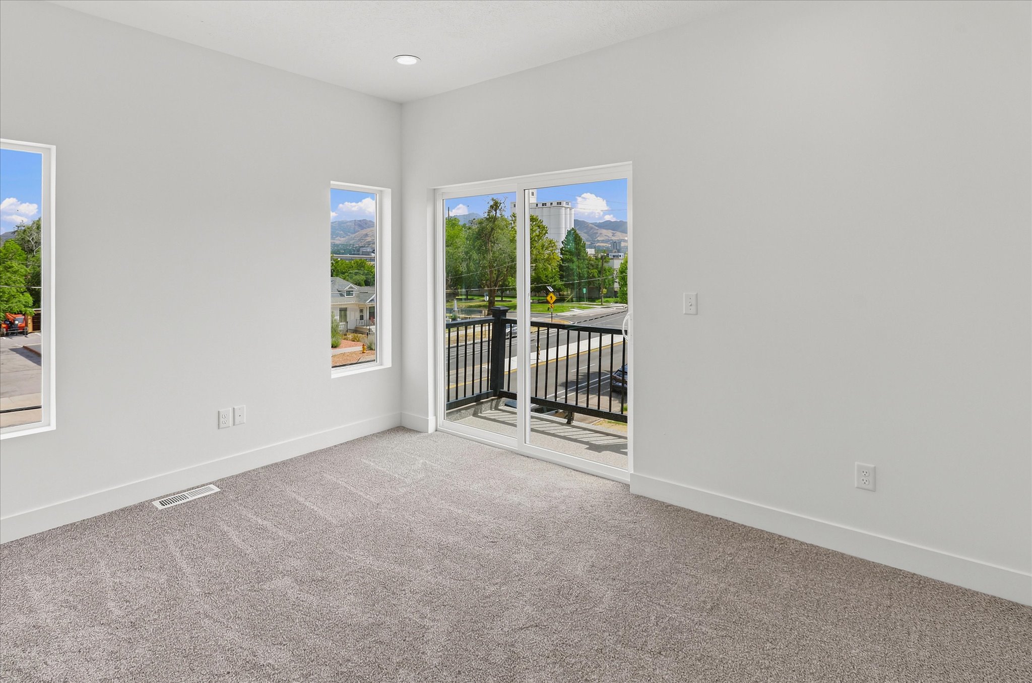 Spacious room featuring light gray carpet flooring and white walls