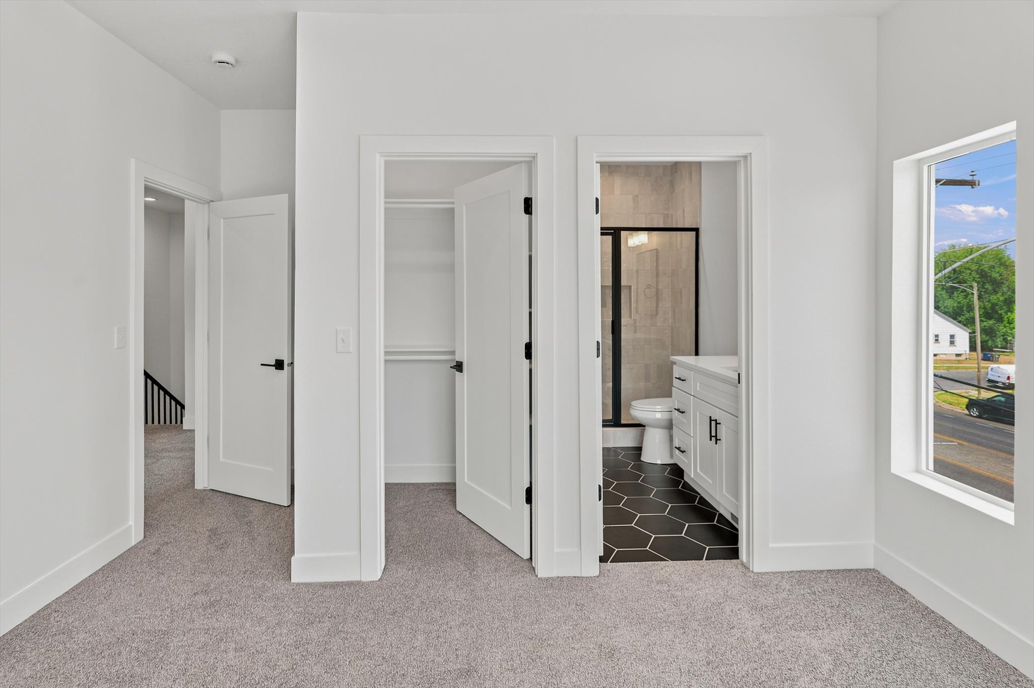 Bedroom featuring neutral gray carpeting and white walls