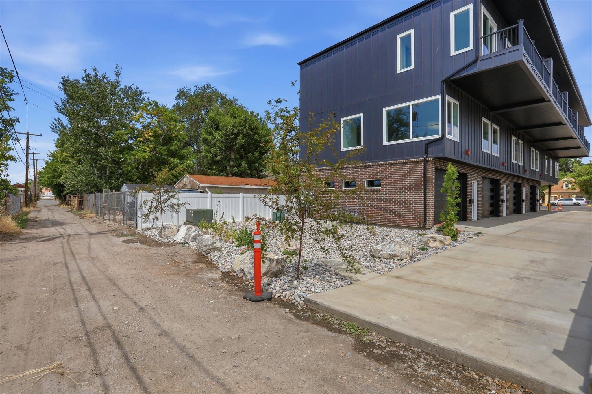 Modern multi-level exterior with dark siding and white trim windows