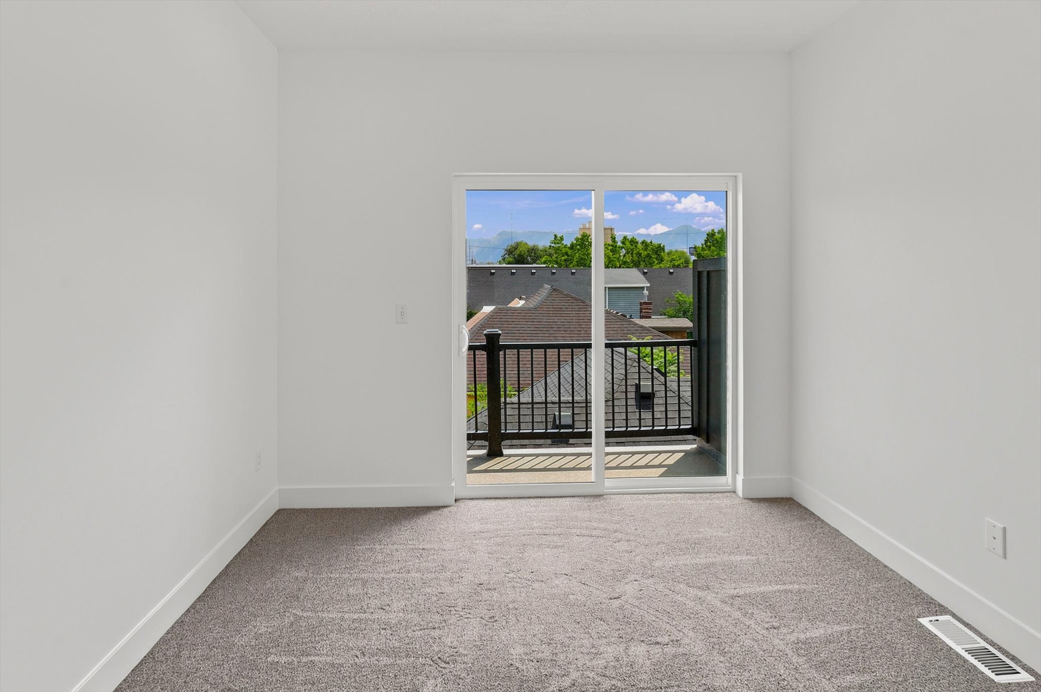 Sliding glass door leading to a private balcony with black metal railing