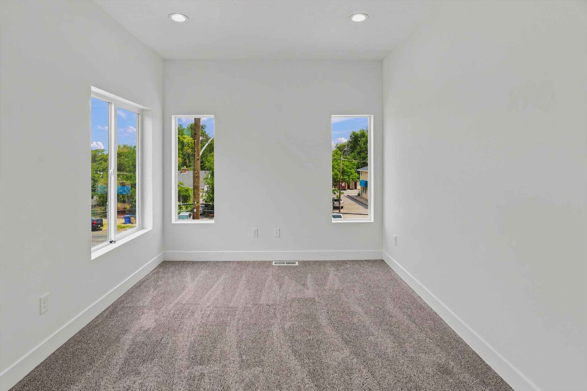 White walls with recessed lighting and a textured gray carpet