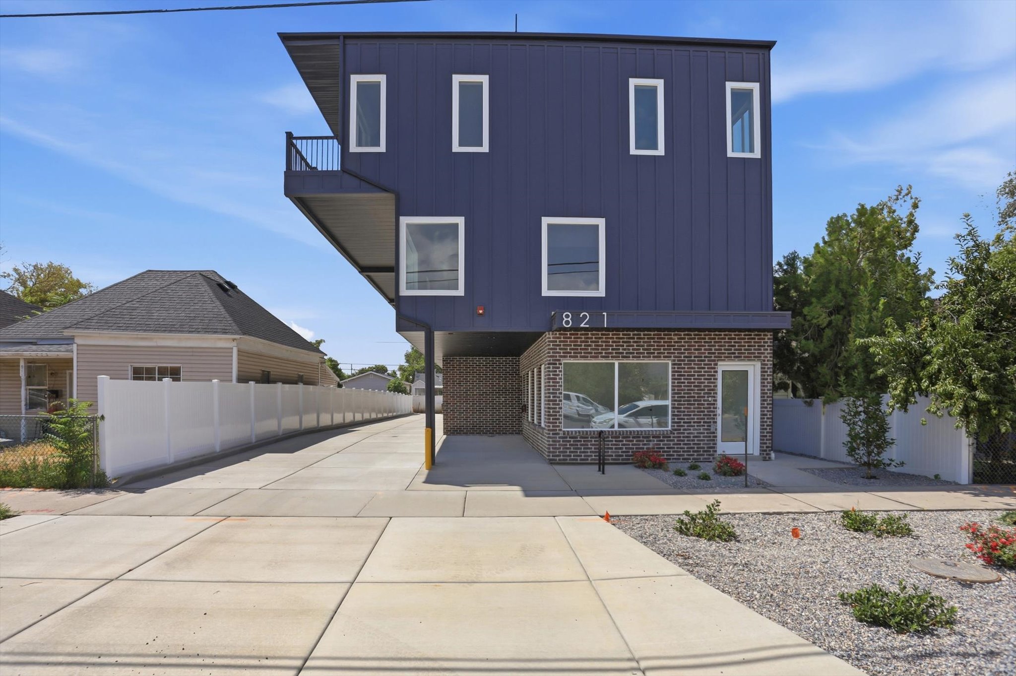 Contemporary multi-story building featuring a dark blue vertical panel exterior and brick facade
