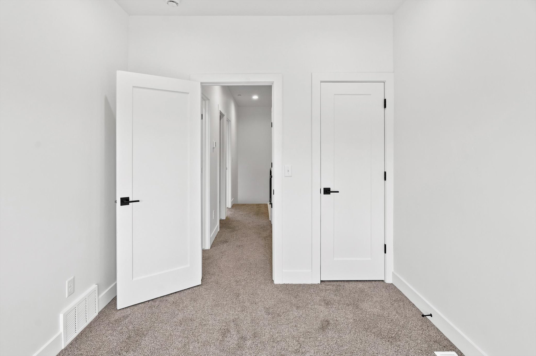 Interior room featuring neutral carpeting and white walls