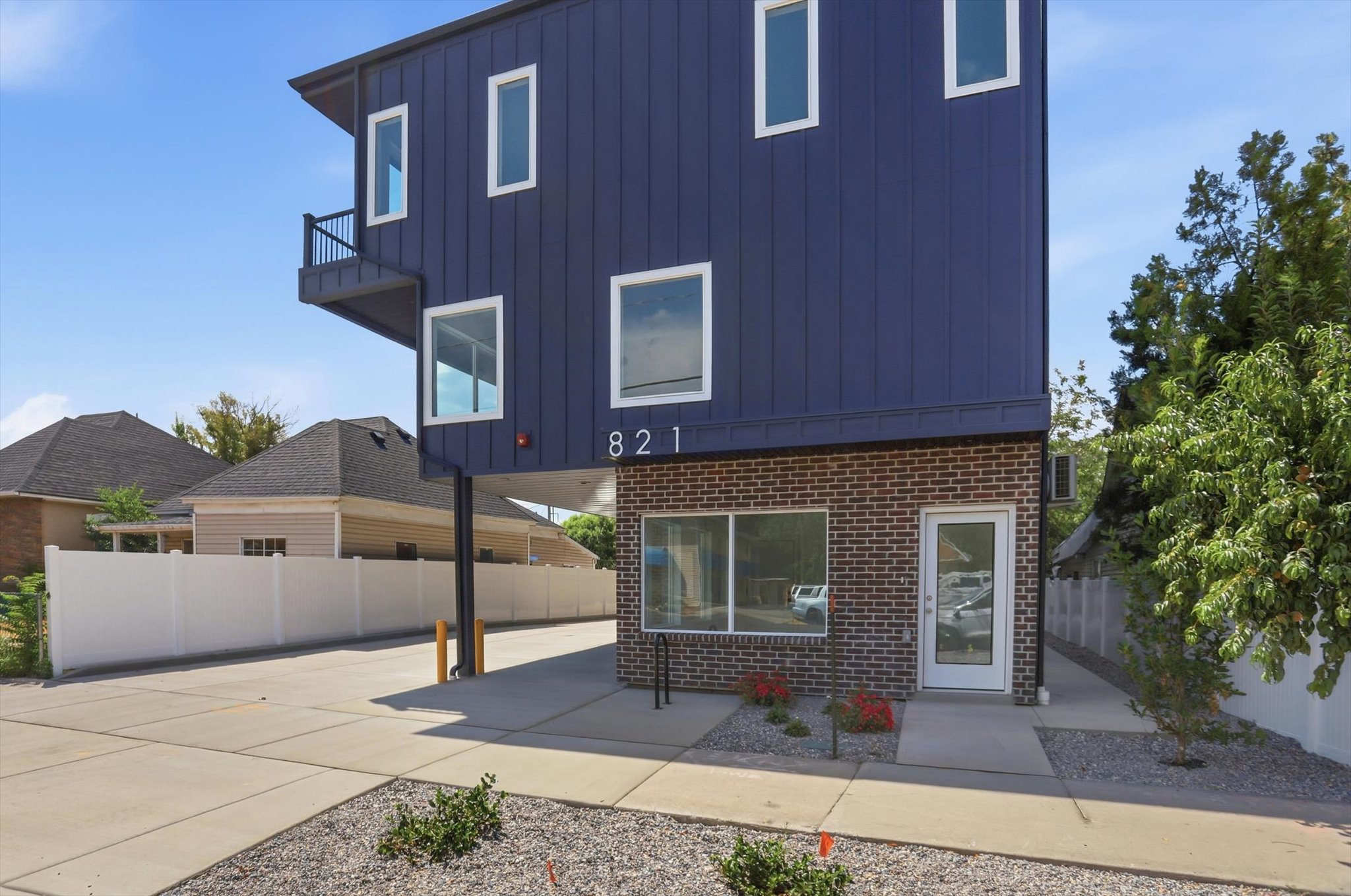 Modern exterior featuring dark blue siding and a brick facade