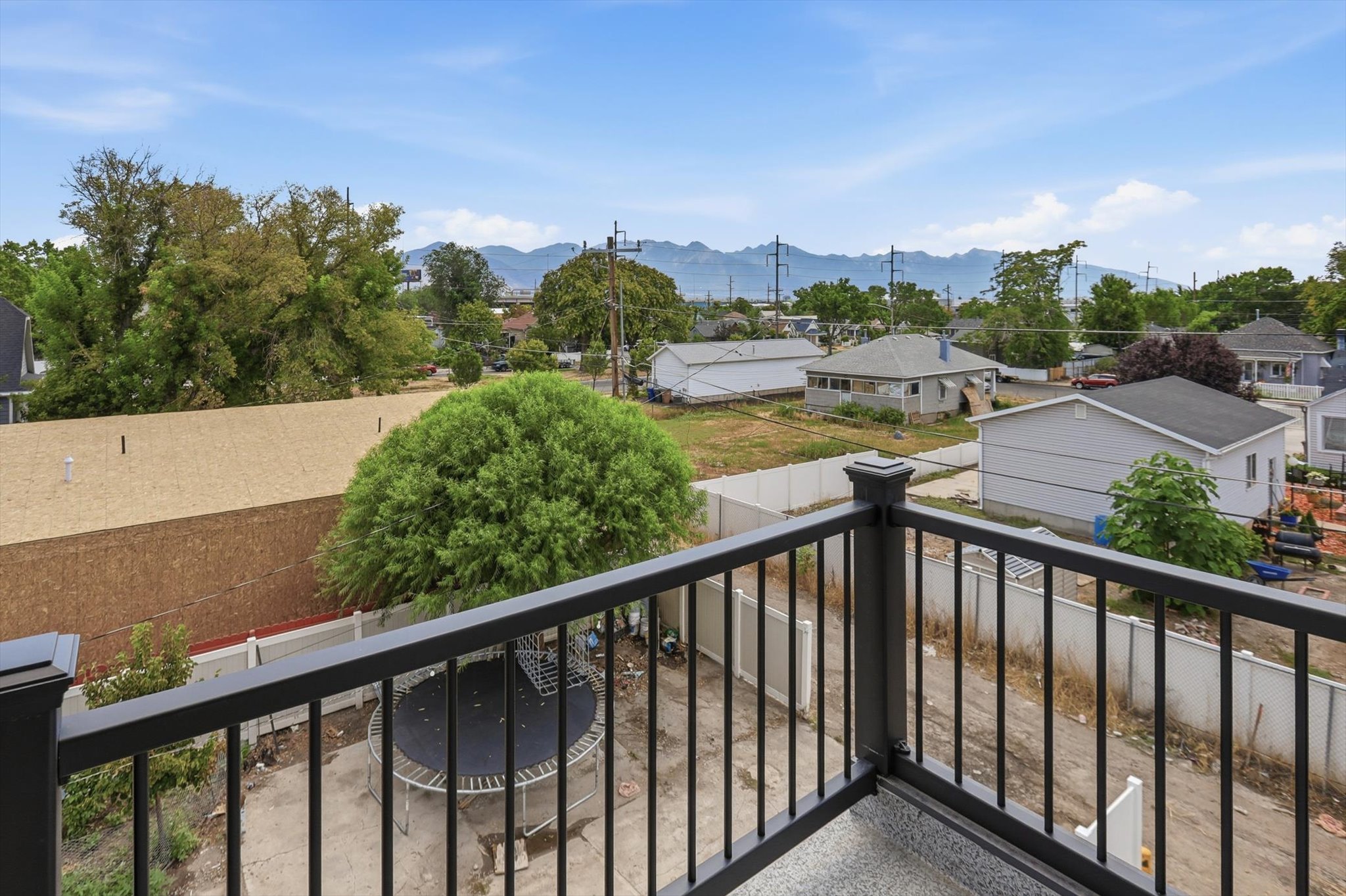 Exterior balcony featuring black metal railings and a grey textured floor