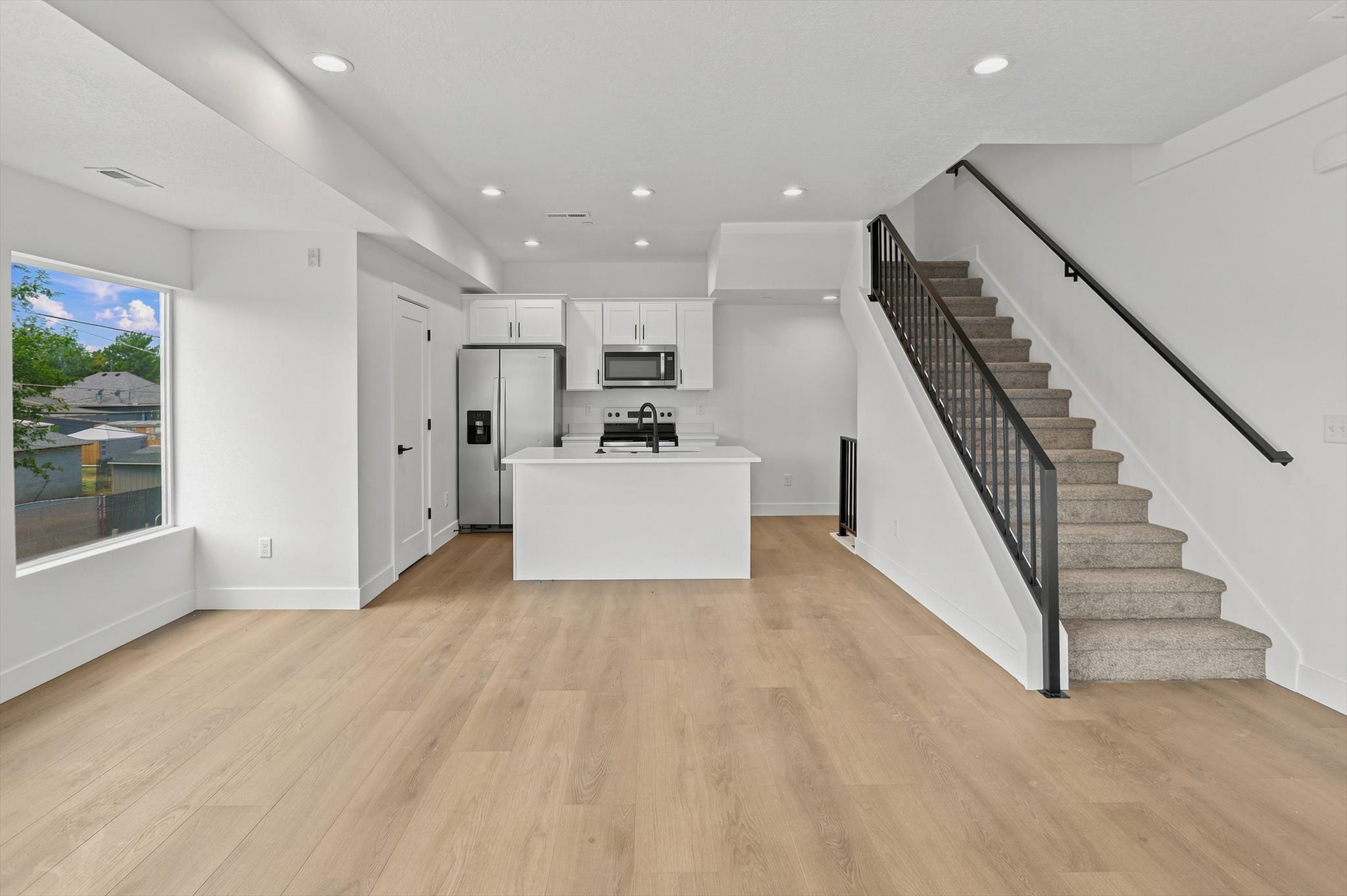 Open-concept living area featuring wood-finish flooring and recessed lighting throughout
