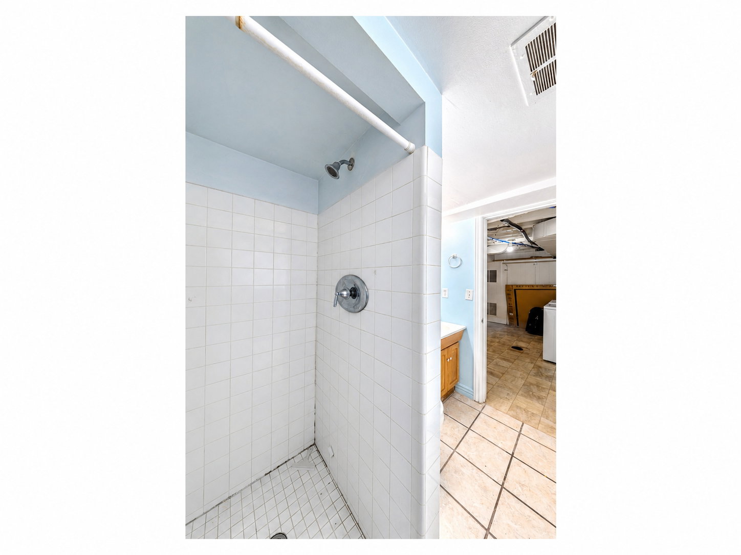 Shower stall featuring white subway tile, a chrome showerhead, and a chrome single-handle control