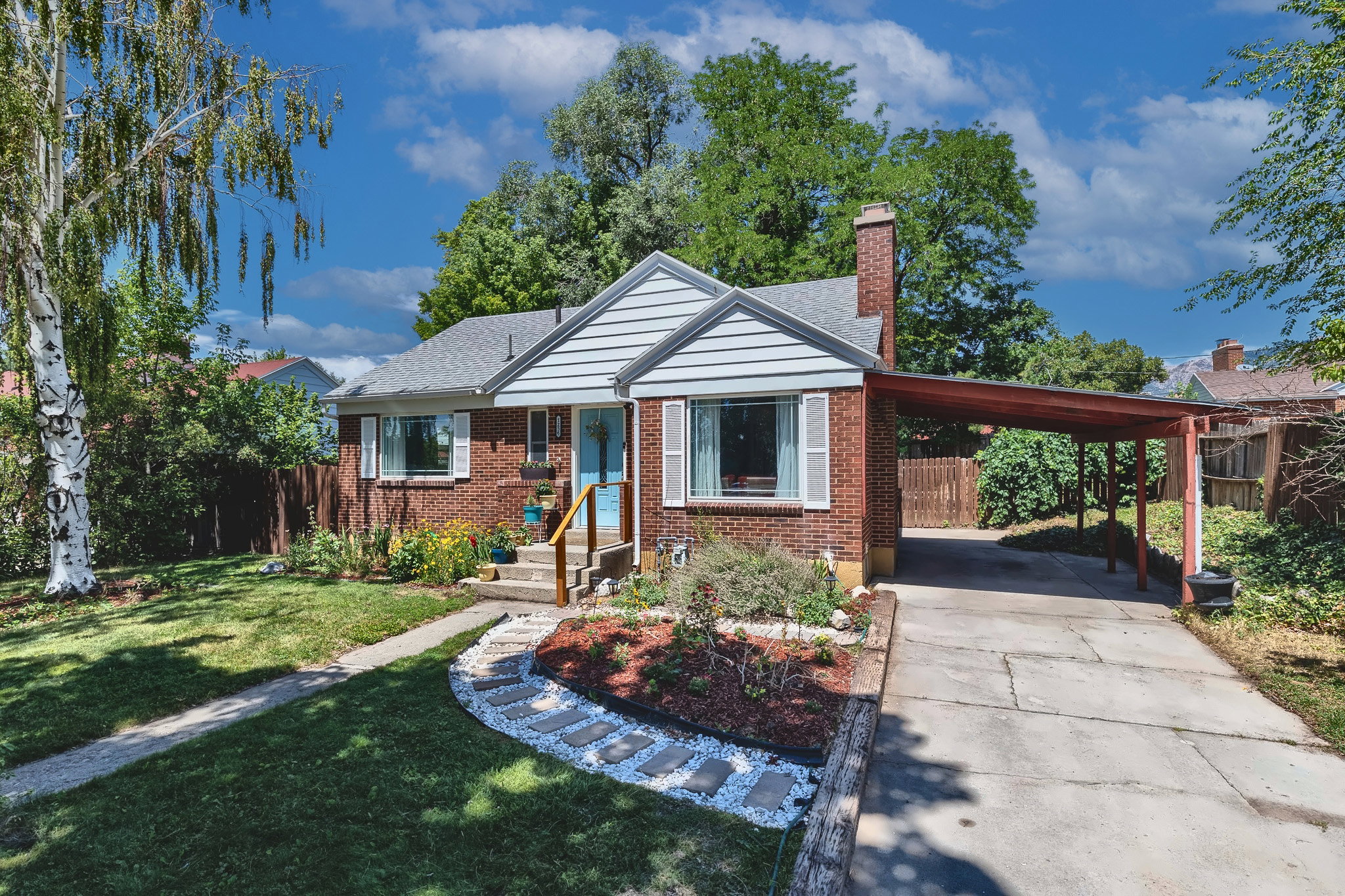 Brick facade home featuring white siding gables and a gray shingle roof